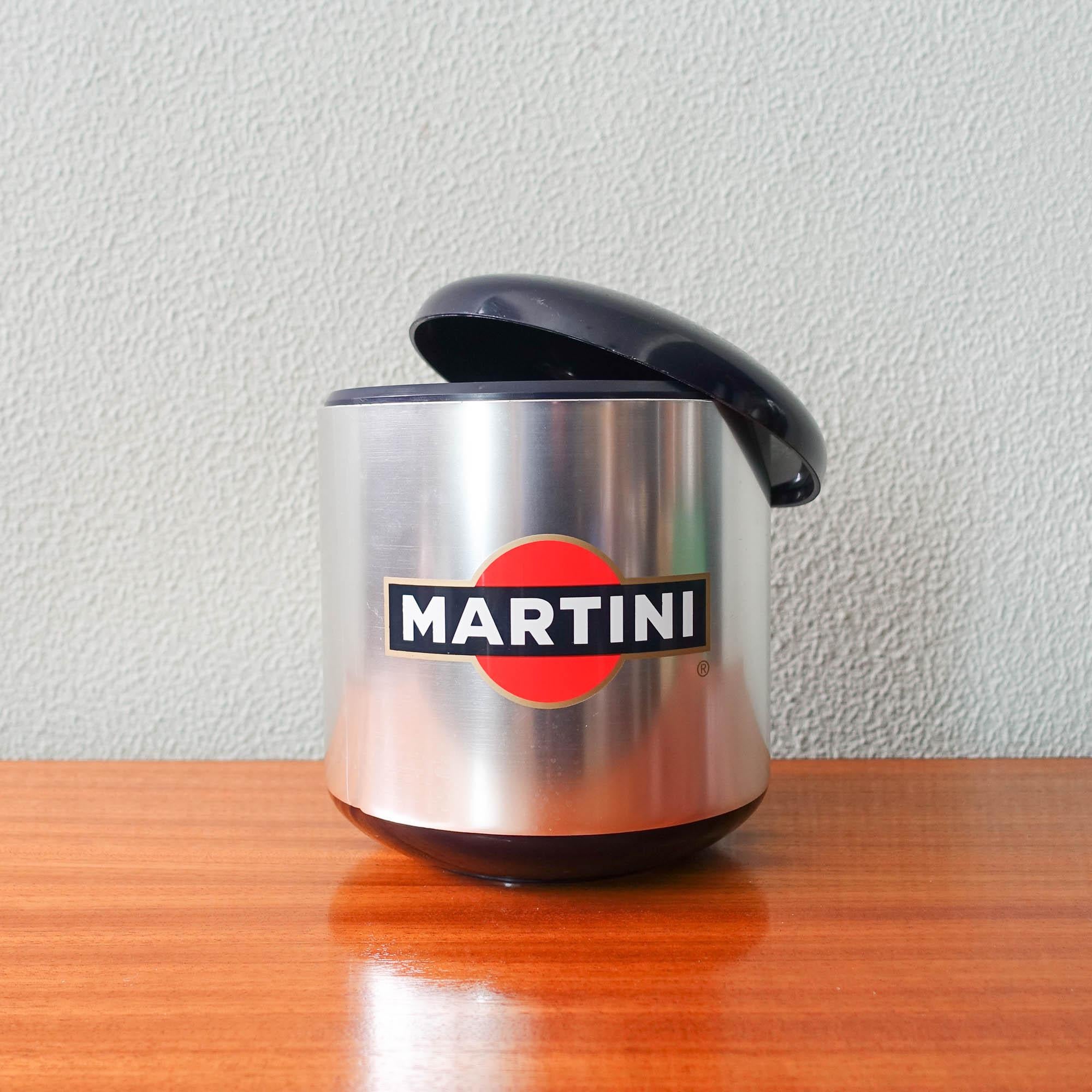 This ice bucket was produced by Diamond Photofoil Ltd, in Kent, United Kingdom, during the 1990's. It was a brand activation piece used in bars and discos to promote Martini. 
The ice bucket has a lid to close and maintain the temperature of the