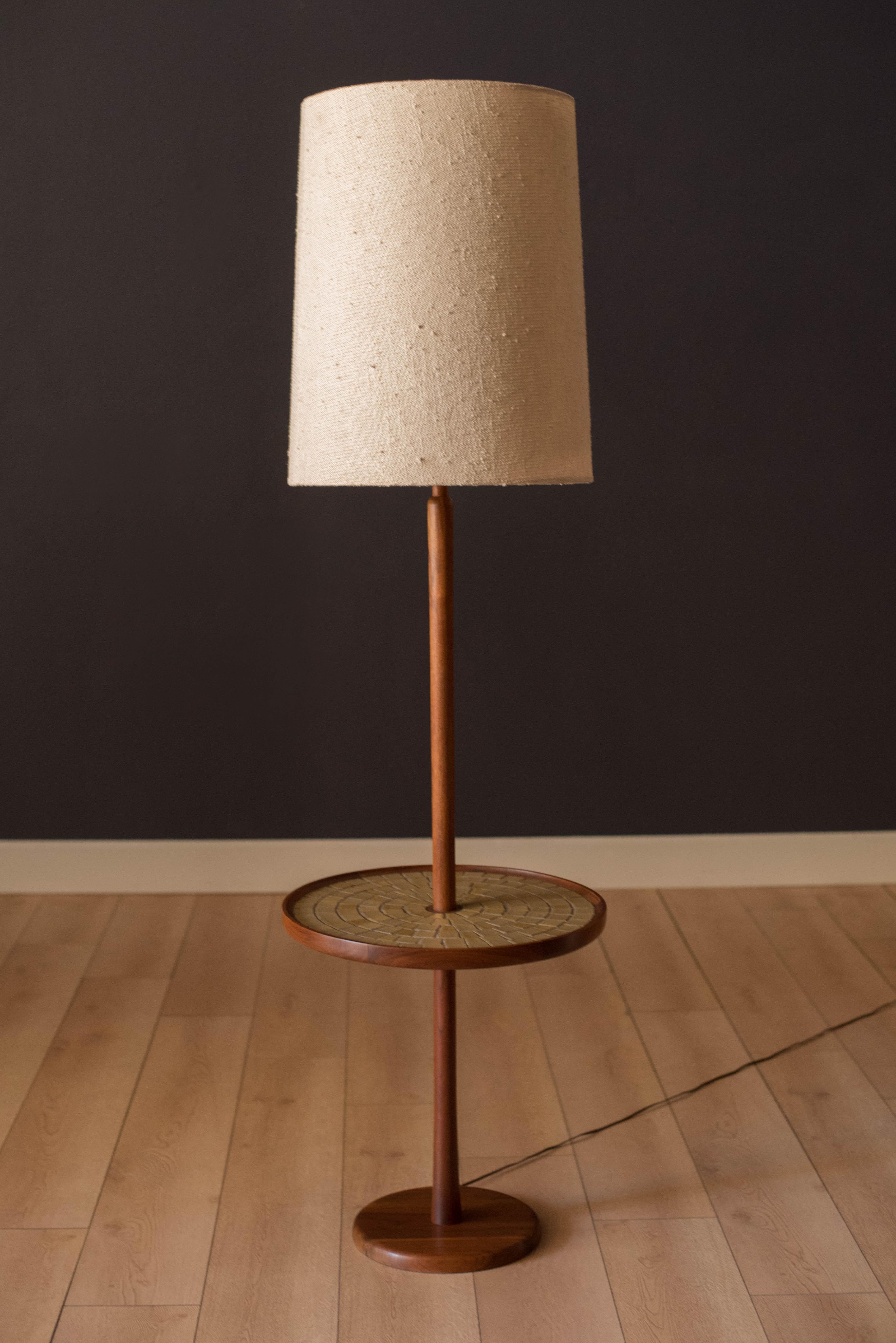 Mid-Century Modern floor lamp with attached round side table designed by Jane and Gordon Martz for Marshall Studios. This versatile piece features a walnut base and a unique inlay of ceramic tile including signature Martz details. Lamp shade is not