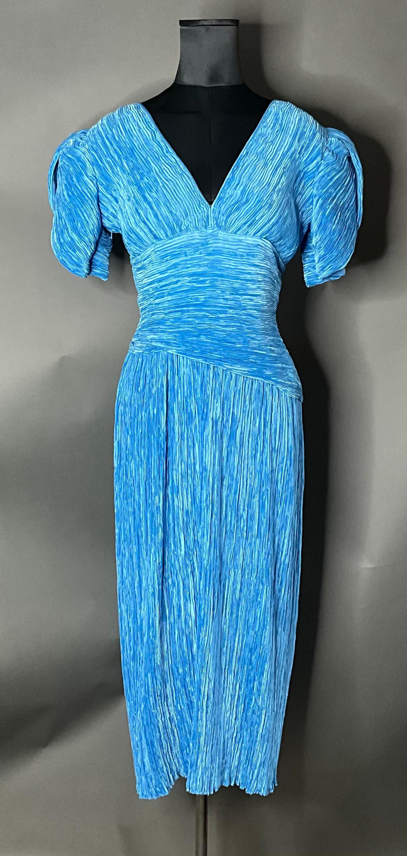 The Vintage Mary McFadden Blue Pleated Dress is a beautifully crafted piece that combines innovative pleating, timeless elegance, and luxurious materials. With its flowing silhouette, vibrant color, and intricate design, it captures the essence of
