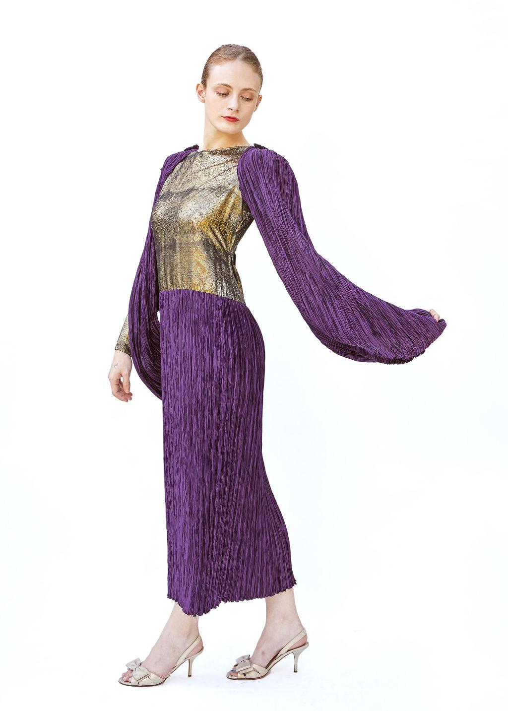 This Mary McFadden Vintage Purple Pleated Dress is an iconic piece that embodies the designer’s signature blend of Grecian-inspired elegance and modern luxury. Crafted in a rich, royal purple, the dress features meticulously hand-pleated fabric that