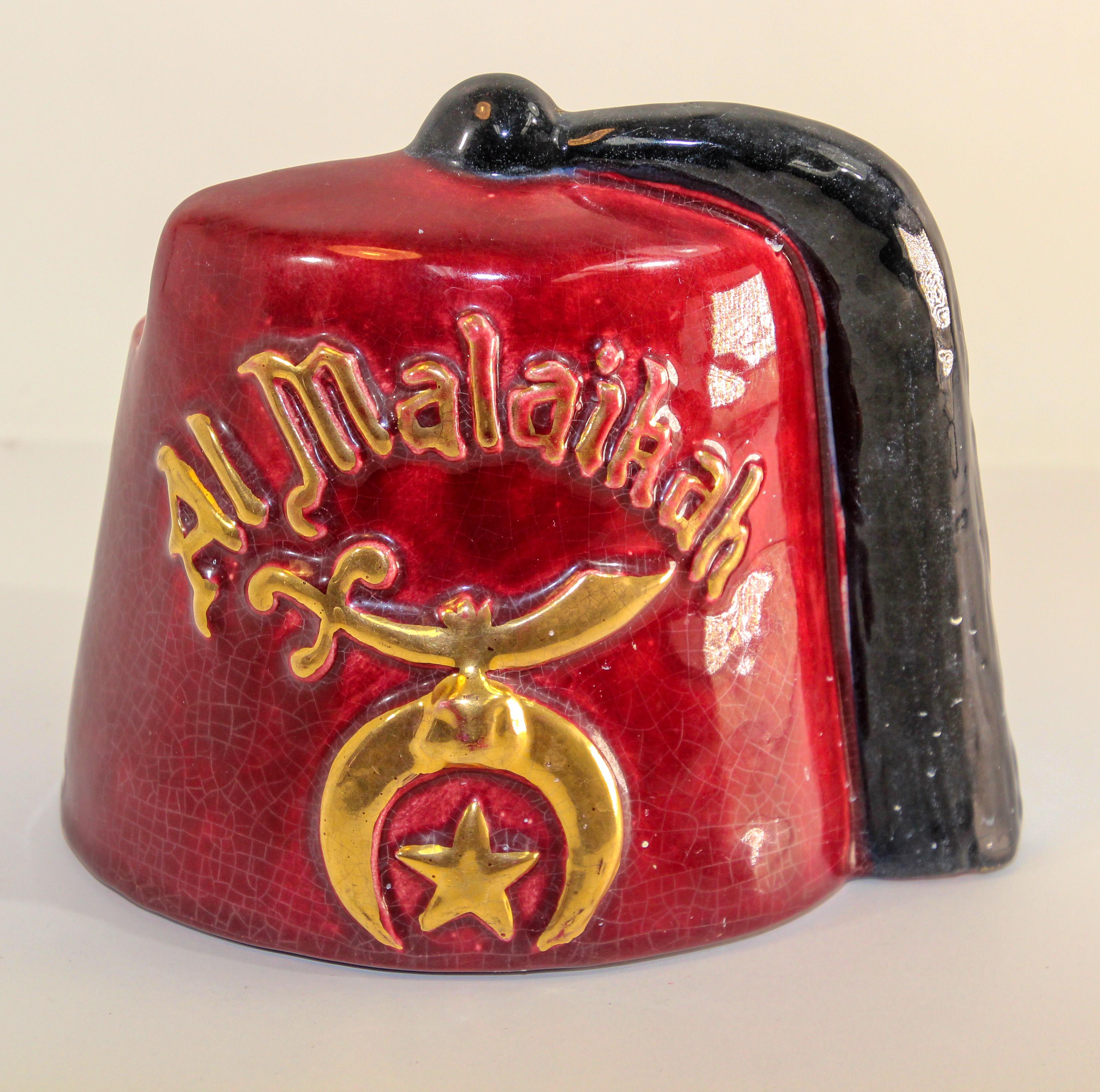 AL Malaikah vintage Masonic Shriner iconic burgundy Fez hat design ceramic planter or vase.
Vintage fez hat from Los Angeles Al Malaikah Shriner masonic lodge.
This vintage Al Malaikah Shriner's fez in burgundy ceramic with gold script , sword,