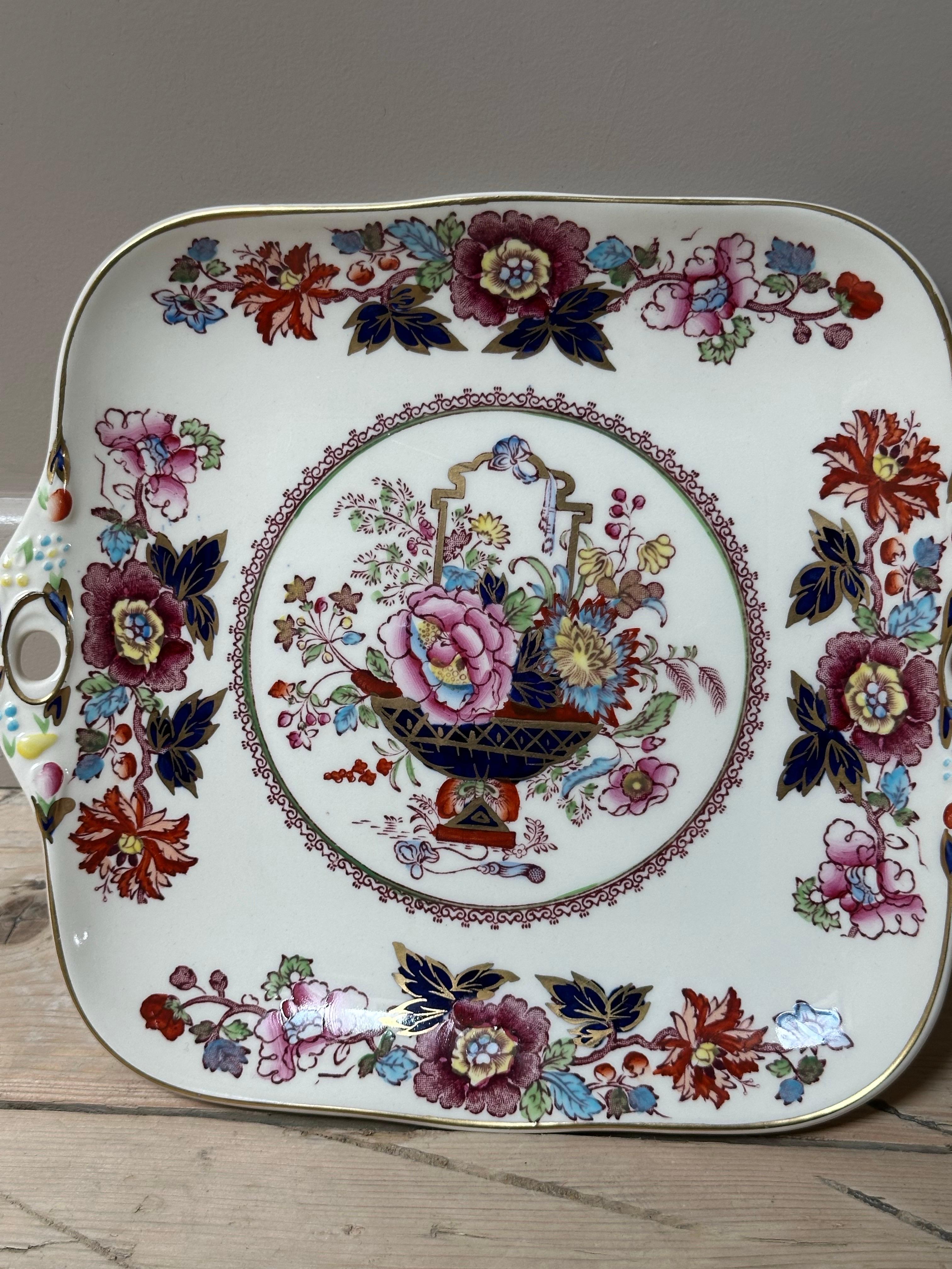 Bringen Sie einen Hauch von englischem Charme auf Ihren Tisch mit dieser Servierplatte aus Mason's Ironstone mit dem begehrten Brokatmuster, das für seine lebhaften, mehrfarbigen Blumenmotive bekannt ist, die mit goldenen Akzenten verziert sind.
