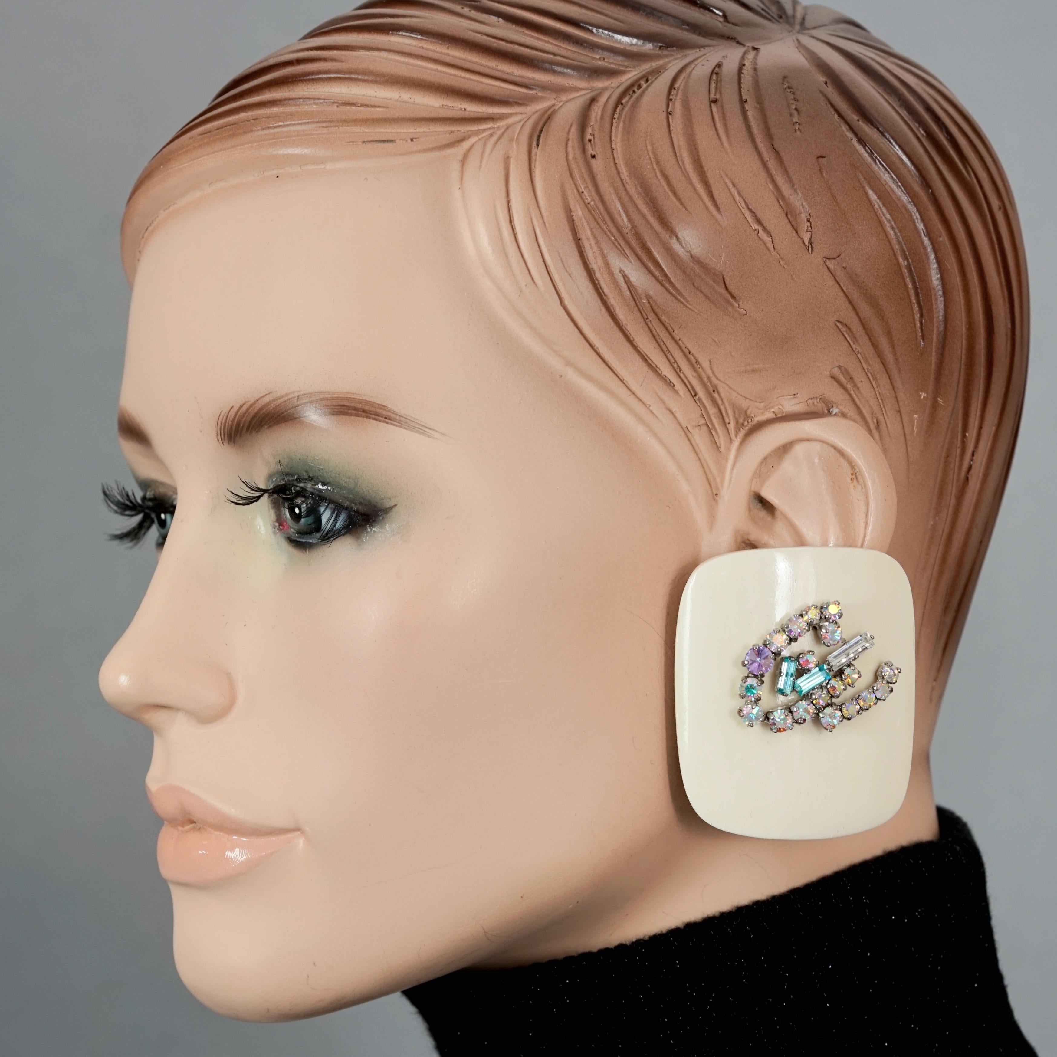 Vintage Massive CHRISTIAN LACROIX Logo Rhinestone Resin Ivory Earrings

Measurements:
Height: 2.20 inches (5.6 cm)
Width: 1.85 inches (4.7 cm)
Weight per Earring: 32 grams

Features:
- 100% Authentic CHRISTIAN LACROIX.
- Massive square white ivory