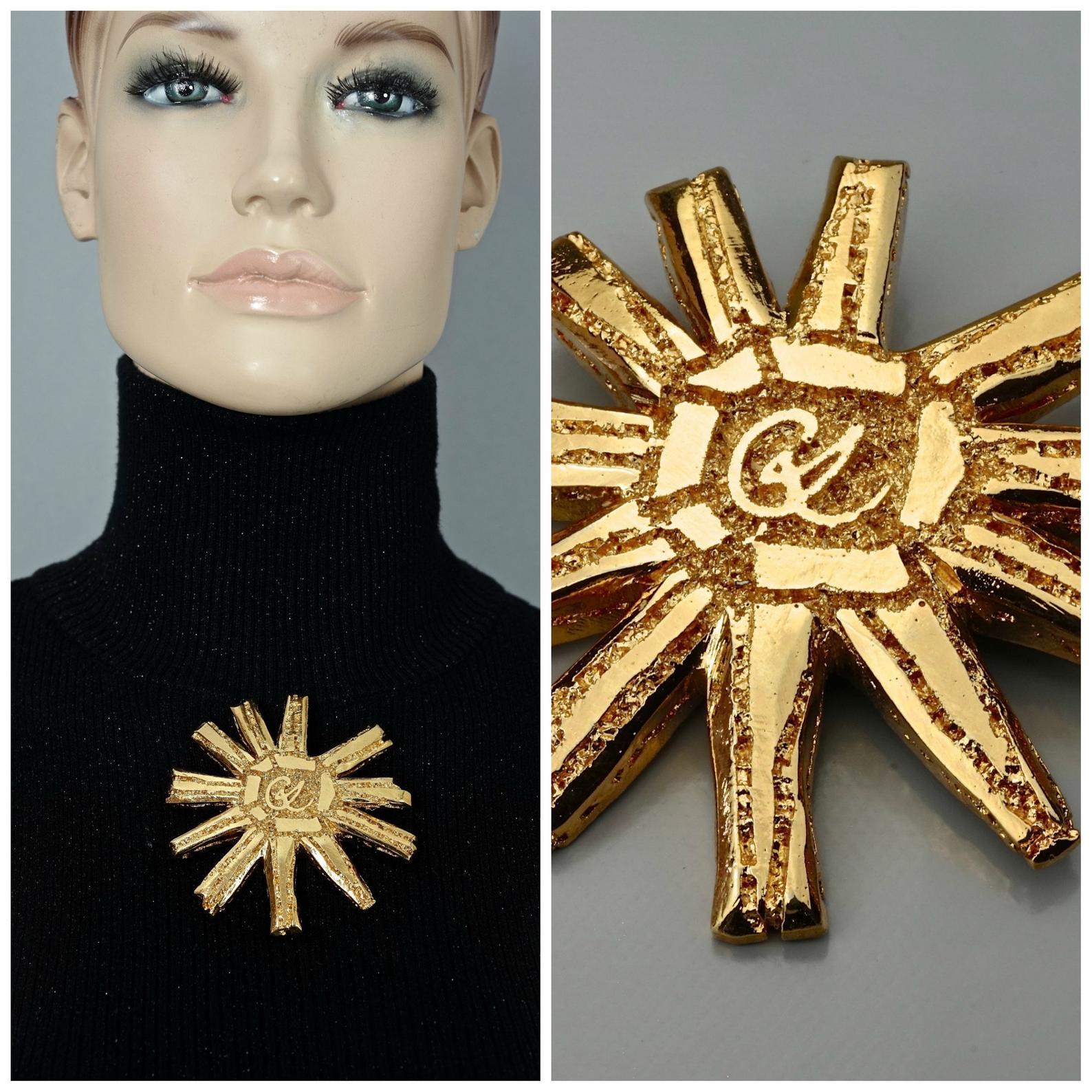 Vintage Massive CHRISTIAN LACROIX Logo Sun Brooch

Measurements:
Height: 3.15 inches (8 cm)
Width: 3.15 inches (8 cm)

Features:
- 100% Authentic CHRISTIAN LACROIX.
- Huge lightweight sun brooch.
- CL logo at the center.
- Gold tone.
- Signed
