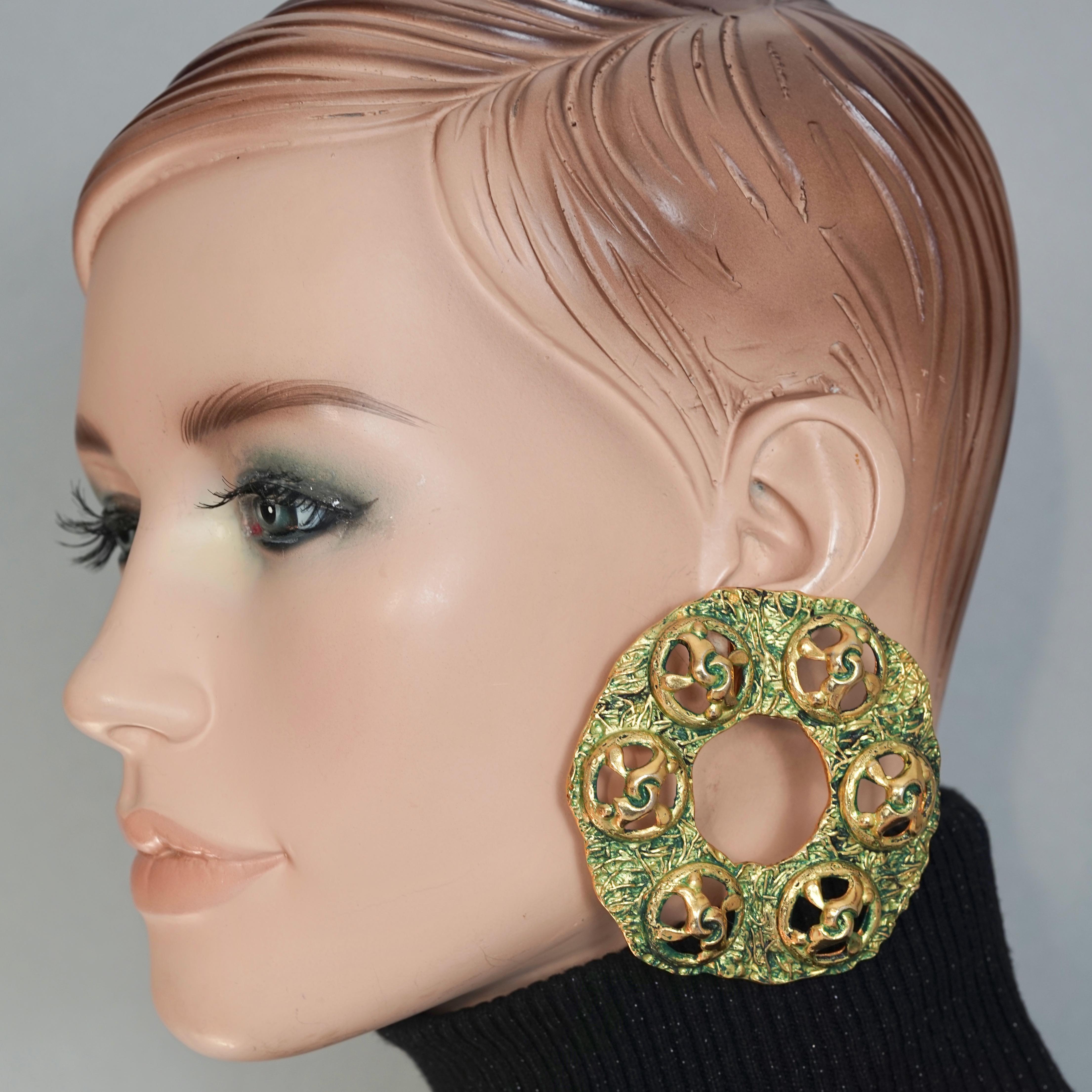 Vintage Massive French Patina Green Enamel Creole Hoop Earrings

Measurements:
Height: 2.75 inches (7 inches)
Width: 2.75 inches (7 inches)
Weight per Earrings: 50 grams

Features:
- Massive textured hoop/ creole earrings.
- Green enamel patina