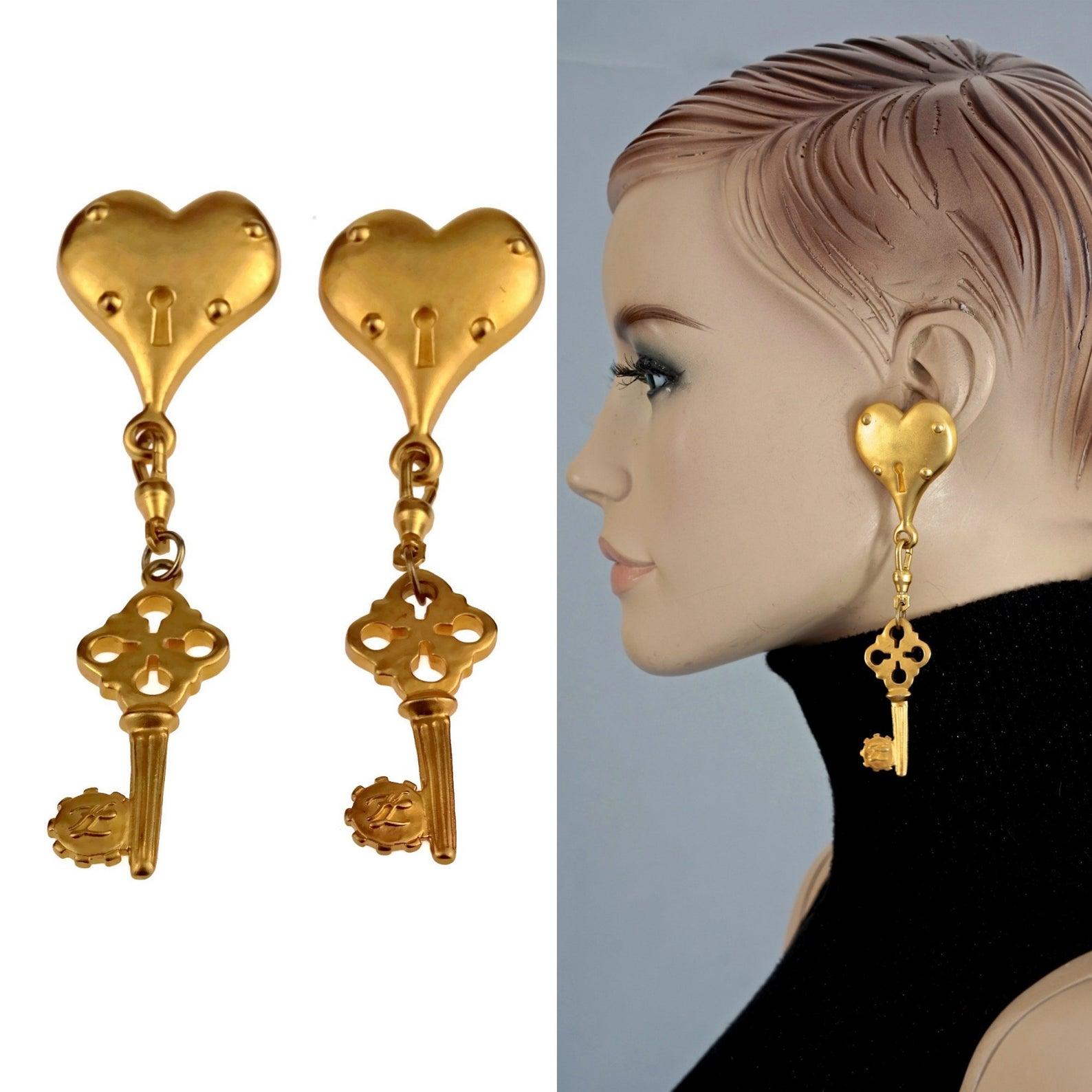 Vintage Massive KARL LAGERFELD Heart Padlock Key Dangling Earrings

Measurements:
Height: 4.68 inches (11.9 cm)
Width: 1.37 inches (3.5 cm)
Weight per Earring: 26 grams

Features:
- 100% Authentic KARL LAGERFELD.
- Long massive earrings in dangling