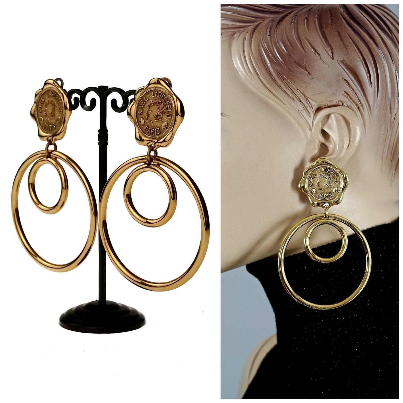 Vintage Massive KARL LAGERFELD Profile Wax Seal Double Hoop Earrings

Measurements:
Height: 3.93 inches (10 cm)
Width: 2.52 inches (6.4 cm)
Weight per Earring: 38 grams

Features:
- 100% Authentic KARL LAGERFELD.
- Lagerfeld wax seal profile with