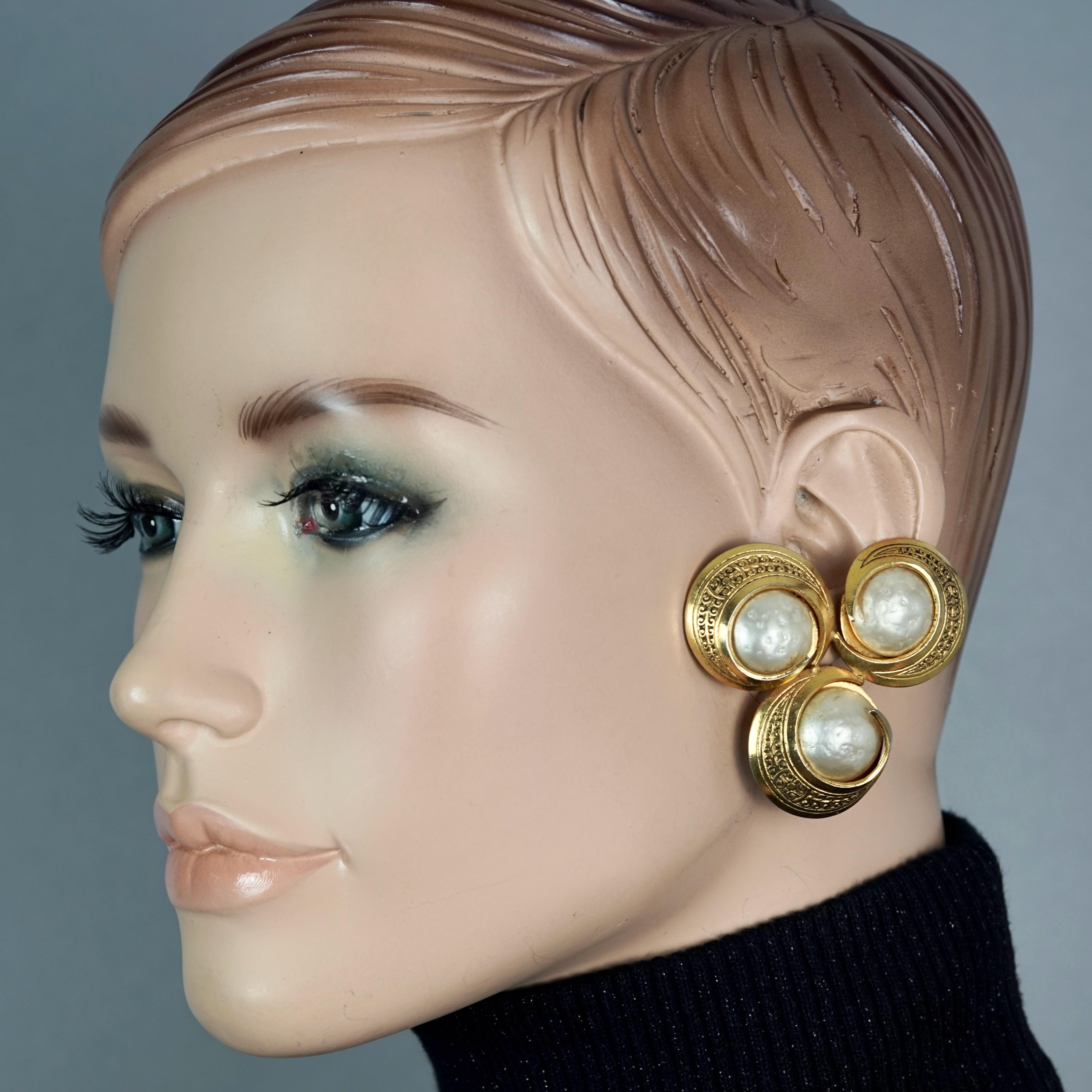 Vintage Massive MERCEDES ROBIROSA Triple Textured Pearls Disc Earrings

Measurements:
Height: 1.97 inches (5 cm)
Width: 2.12 inches (5.4 cm)
Weight per Earring: 29 grams

Features:
- 100% Authentic MERCEDES ROBIROSA.
- Massive triple textured pearls
