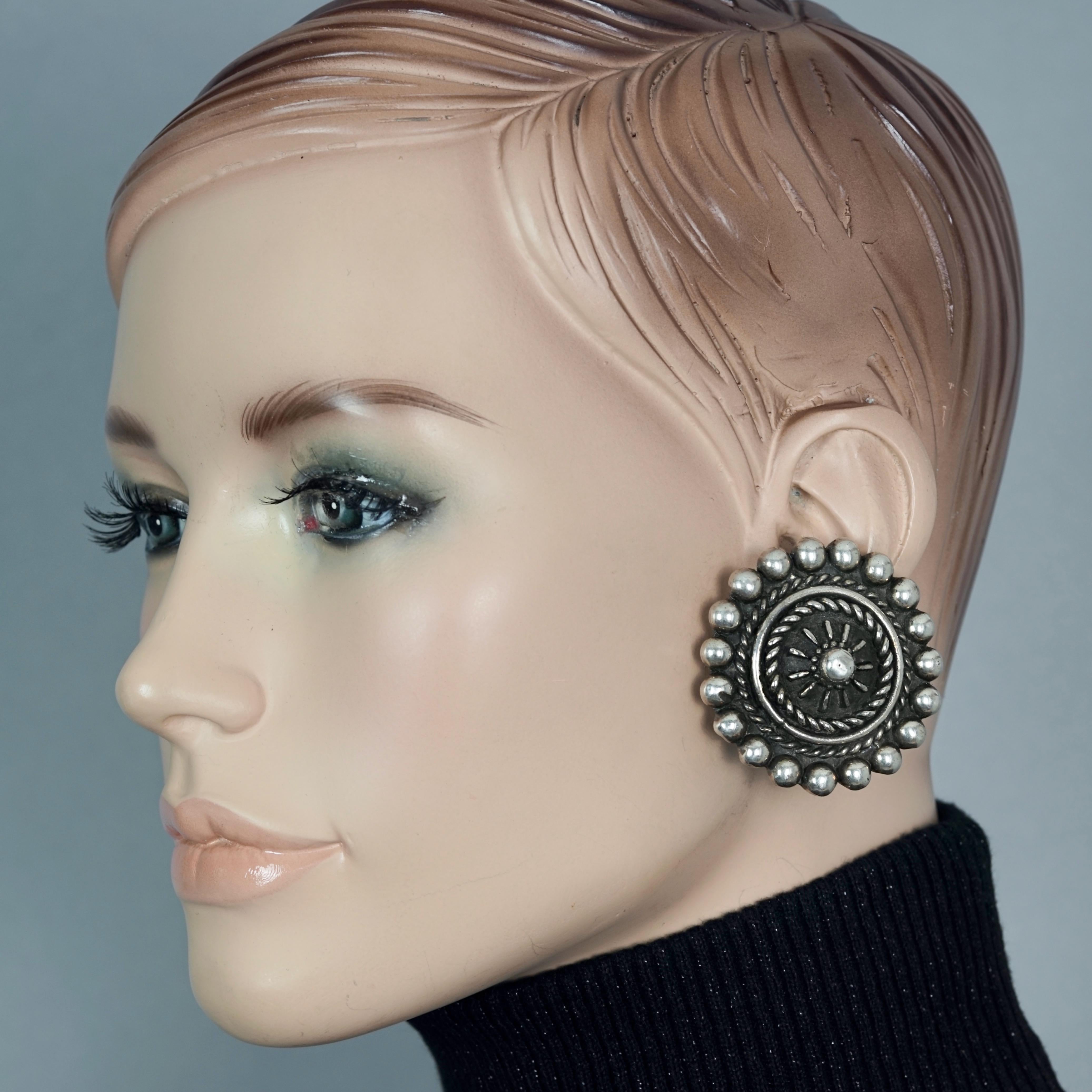 Vintage Massive SCOOTER PARIS Aztec Ethnic Disc Earrings

Measurements:
Height: 1.85 inches (4.7 cm) 
Width: 1.85 inches (4.7 cm) 
Weight per Earring: 19 grams

Features:
- 100% Authentic SCOOTER PARIS.
- Massive Aztec ethnic disc earrings.
- Clip