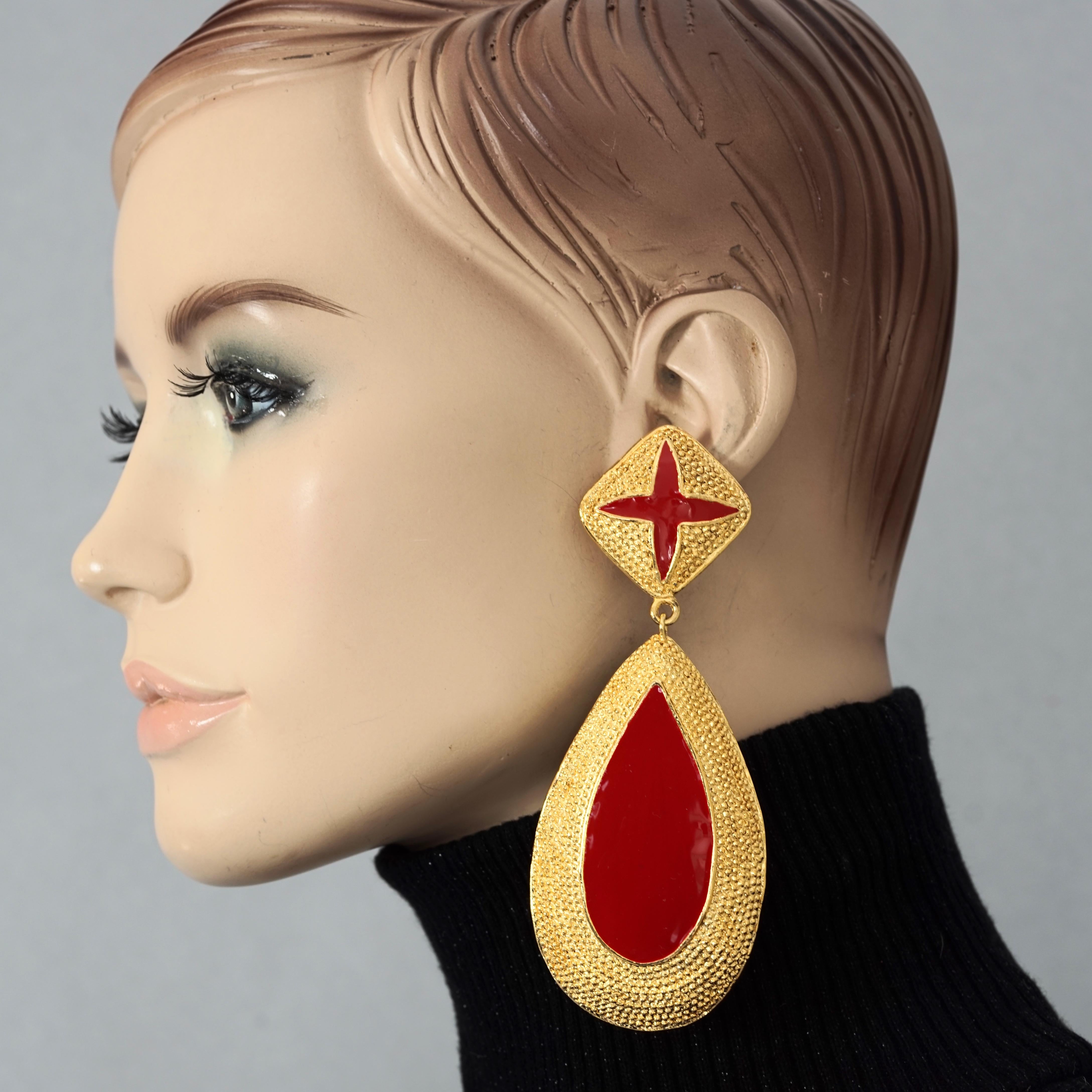 Vintage Massive VALENTINO Red Enamel Dangling Earrings

Measurements:
Height: 4.72 inches (12 cm)
Width: 1.85 inches (4.7 cm)
Weight per Earring: 46 grams

Features:
- 100% Authentic VALENTINO.
- Massive textured gilt dangling earrings with red