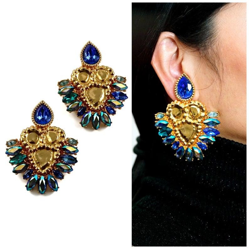 Vintage Massive YVES SAINT LAURENT Iridescent Rhinestones Jewelled Earrings

Measurements:
Height: 3 1/8 inches (7.93 cm)
Width: 2 3/8 inches (6.03 cm)

Features:
- 100% Authentic YVES SAINT LAURENT.
- Faceted iridescent blue rhinestones.
- Massive