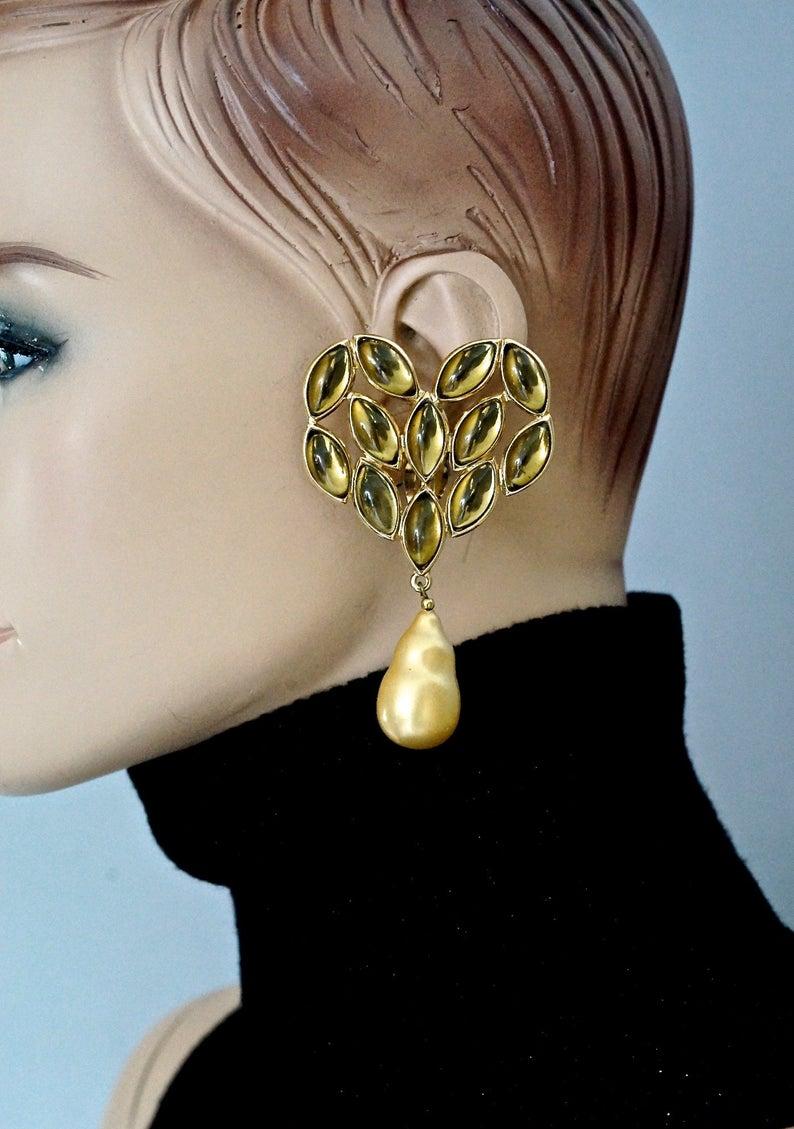Vintage Massive YVES SAINT LAURENT Ysl Heart Cabochon Pearl Dangling Earrings

Measurements:
Height: 3.46 inches (8.8 cm)
Width: 1.96 inches (5 cm)
Weight per Earring: 32 grams

Features:
- 100% Authentic YVES SAINT LAURENT.
- Massive heart earrings