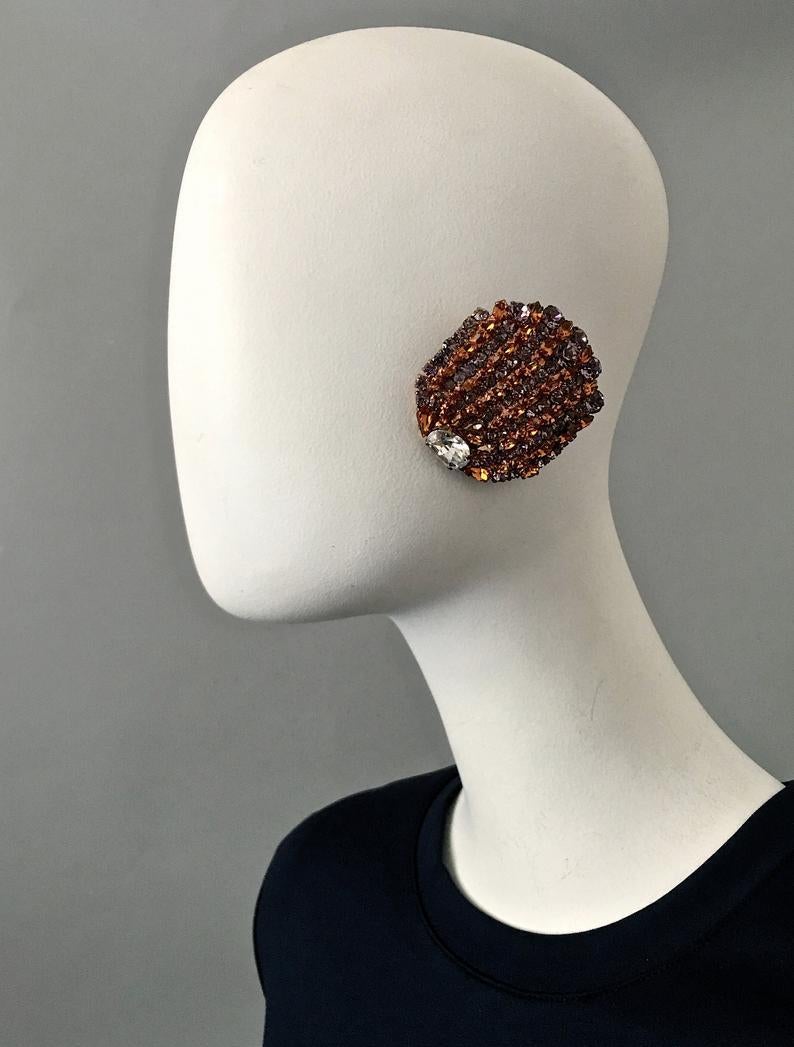 Vintage Massive YVES SAINT LAURENT Ysl Rhinestone Studded Earrings

Measurements:
Height: 2.36 inches (6 cm)
Width: 2 inches (5 cm)

Features:
- 100% Authentic YVES SAINT LAURENT.
- Faceted amber and violet rhinestones.
- Bronze tone hardware.
-