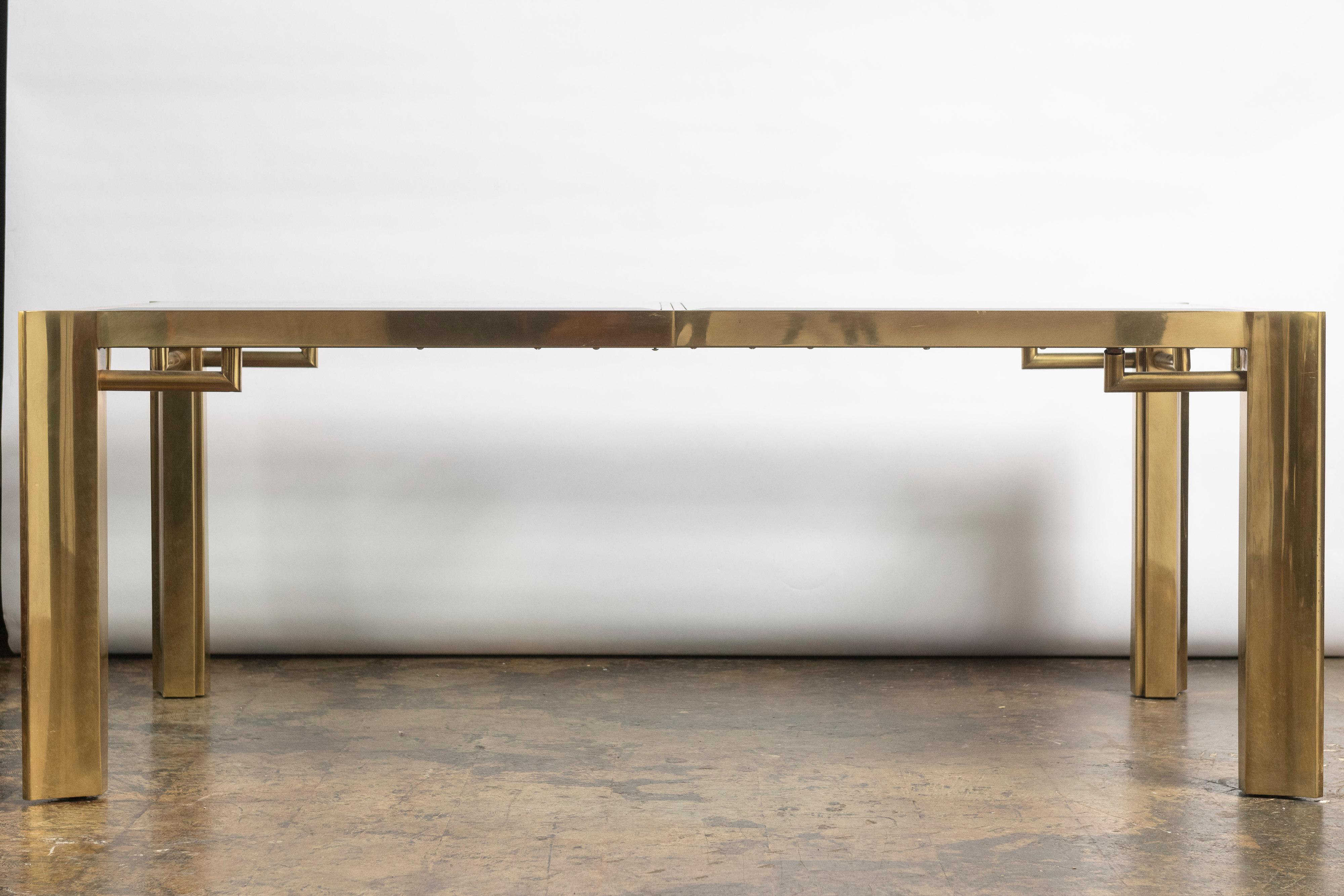 This Mastercraft table is an excellent representation of contemporary design of the 1960-1970s. Made of brass and inset beveled glass, with detailed fretwork on the legs, this vintage dining table is sure to be the place to gather for many a family