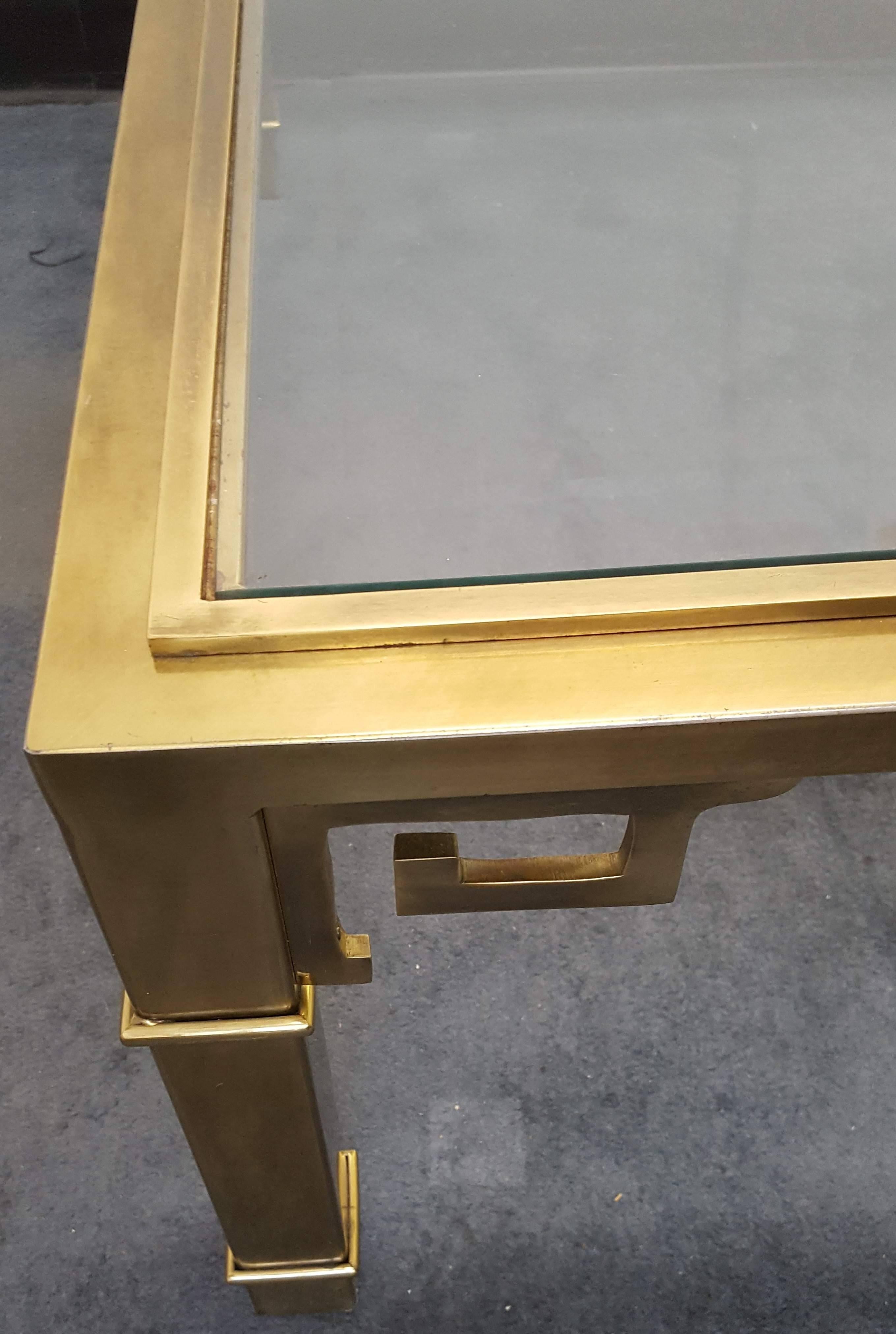 Classic, beautifully crafted vintage brass and glass Mastercraft square coffee table with Greek key details around each leg. Beveled glass top. 1970s.