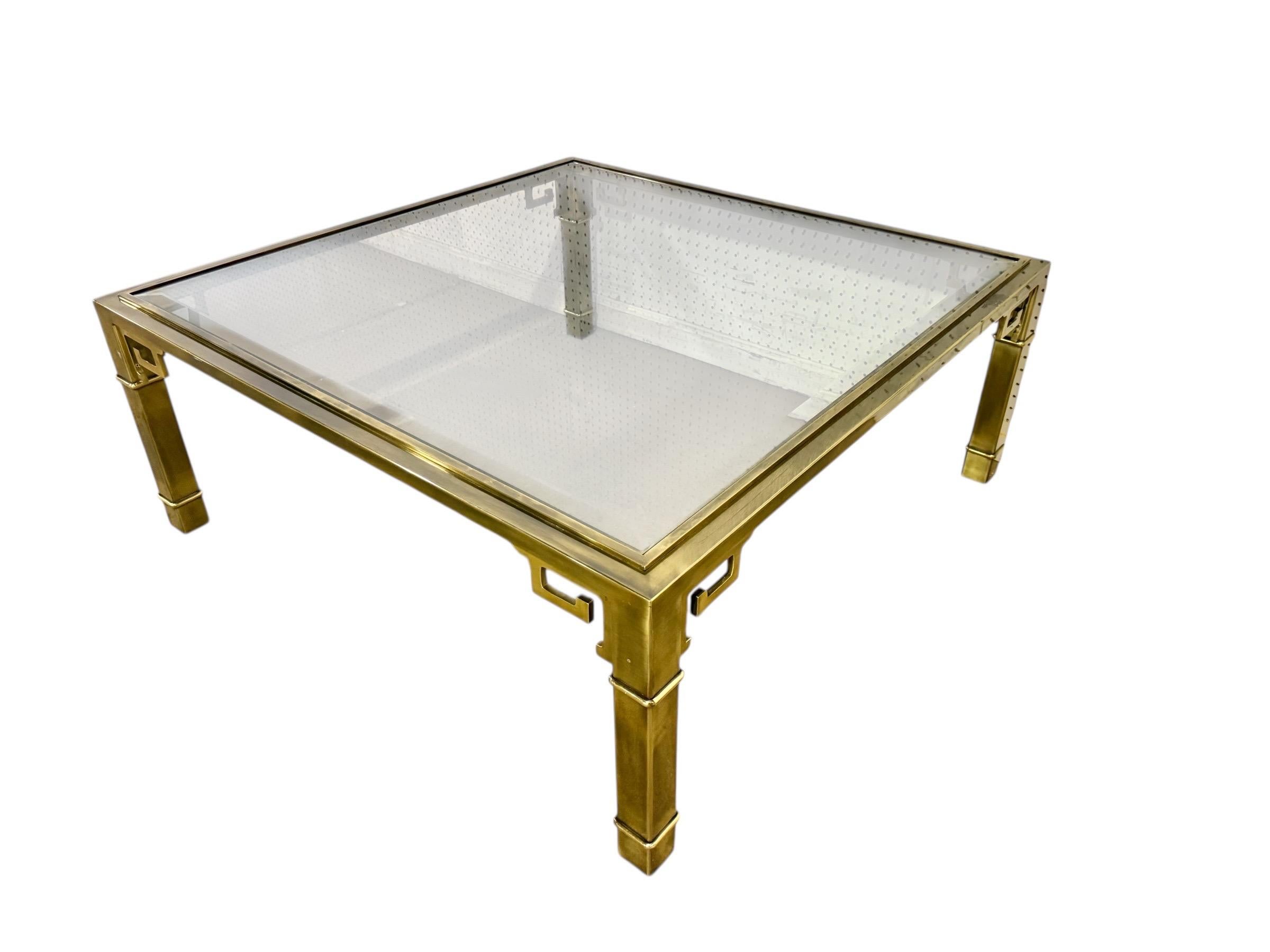 Cette annonce concerne une table basse vintage Mastercraft Greek Key. Elle se caractérise par un design rectiligne, un cadre en laiton et un plateau en verre rectangulaire. Il s'agit d'une combinaison exceptionnelle de qualité et de design de la