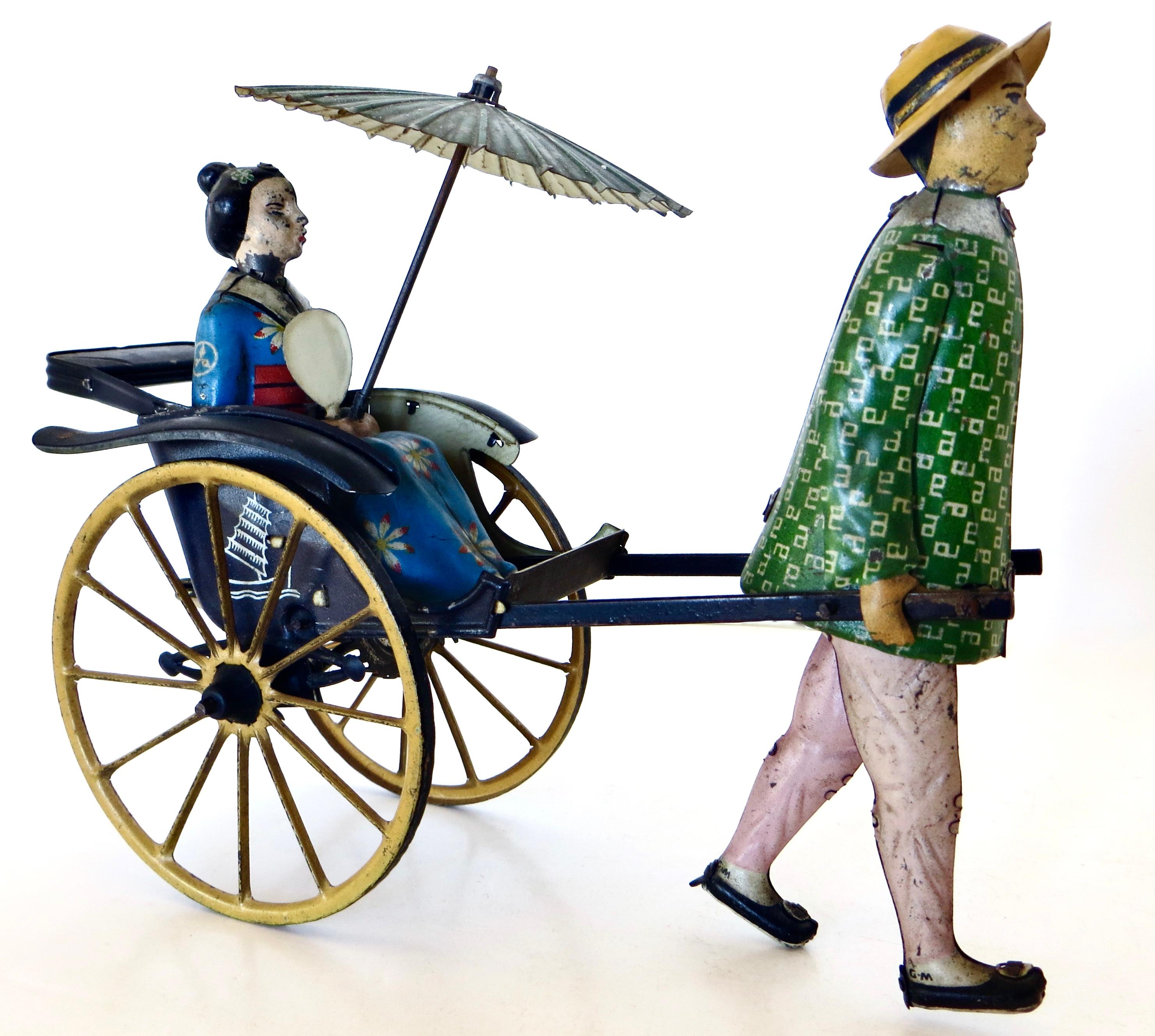  Early 1900's German hand painted and lithographed tin wind-up toy, by premier tin and whimsical toy maker, Ernest Paul Lehman, circa 1913. This charming and unique toy portrays a Japanese man pulling a seated geisha woman in the back of a rickshaw.
