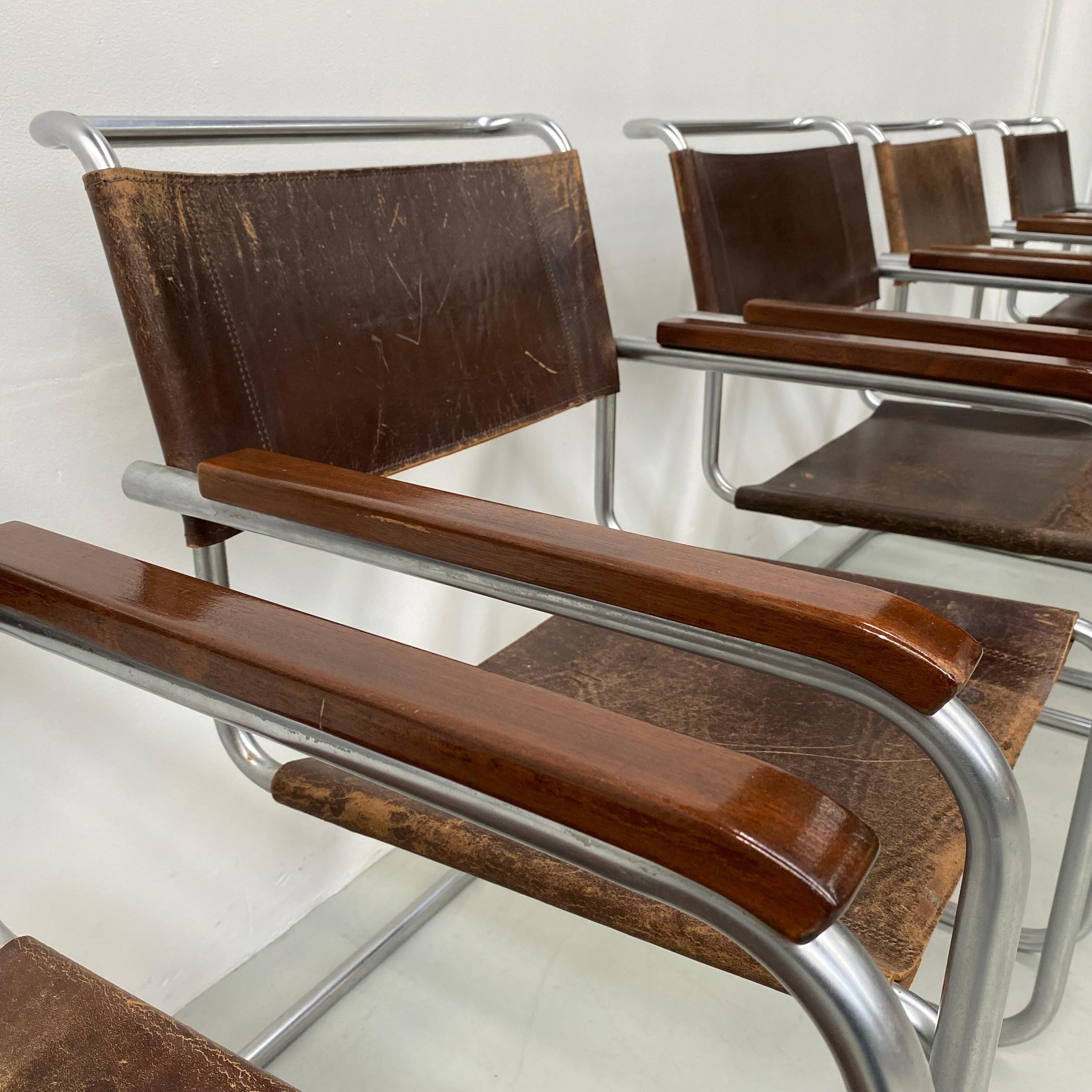These set of 5, B34 chairs were designed by Marcel Breuer between 1920 and 1949 for Thonet in Germany. The iconic chair features a steel matt chromed tubular frame , 2 wooden armrests and a brown saddle leather backrest and seating with patina. As