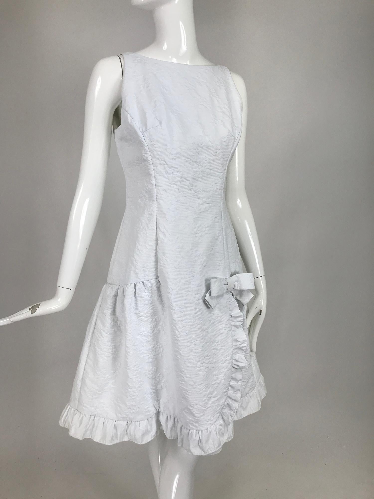 Vintage Matelassé, white cotton, ruffle sun dress from the 1960s. Sleeveless, jewel neckline, princess seam dress in lightweight quilt texture white cotton. Drop waist dress with a bow tie at the hip front, the skirt has a gathered ruffle edge trim.