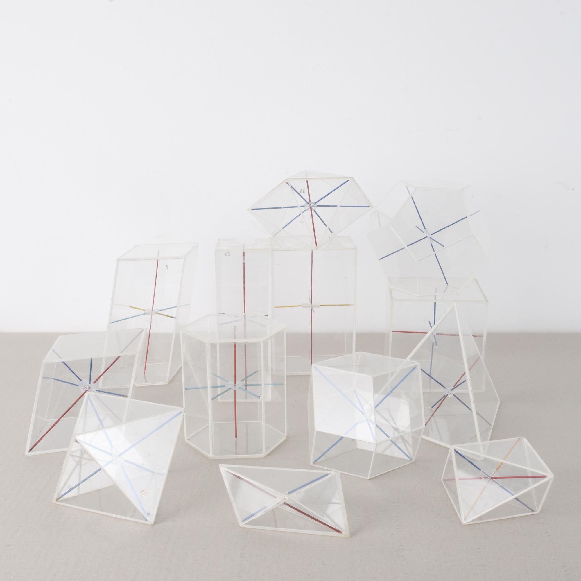These geometric-shaped mathematical teaching aids were made in the former Czechoslovakia, circa 1960. The clear plastic cases house arrangements of red, blue, and yellow metal rods, which show how the forms can be divided. The assortment of
