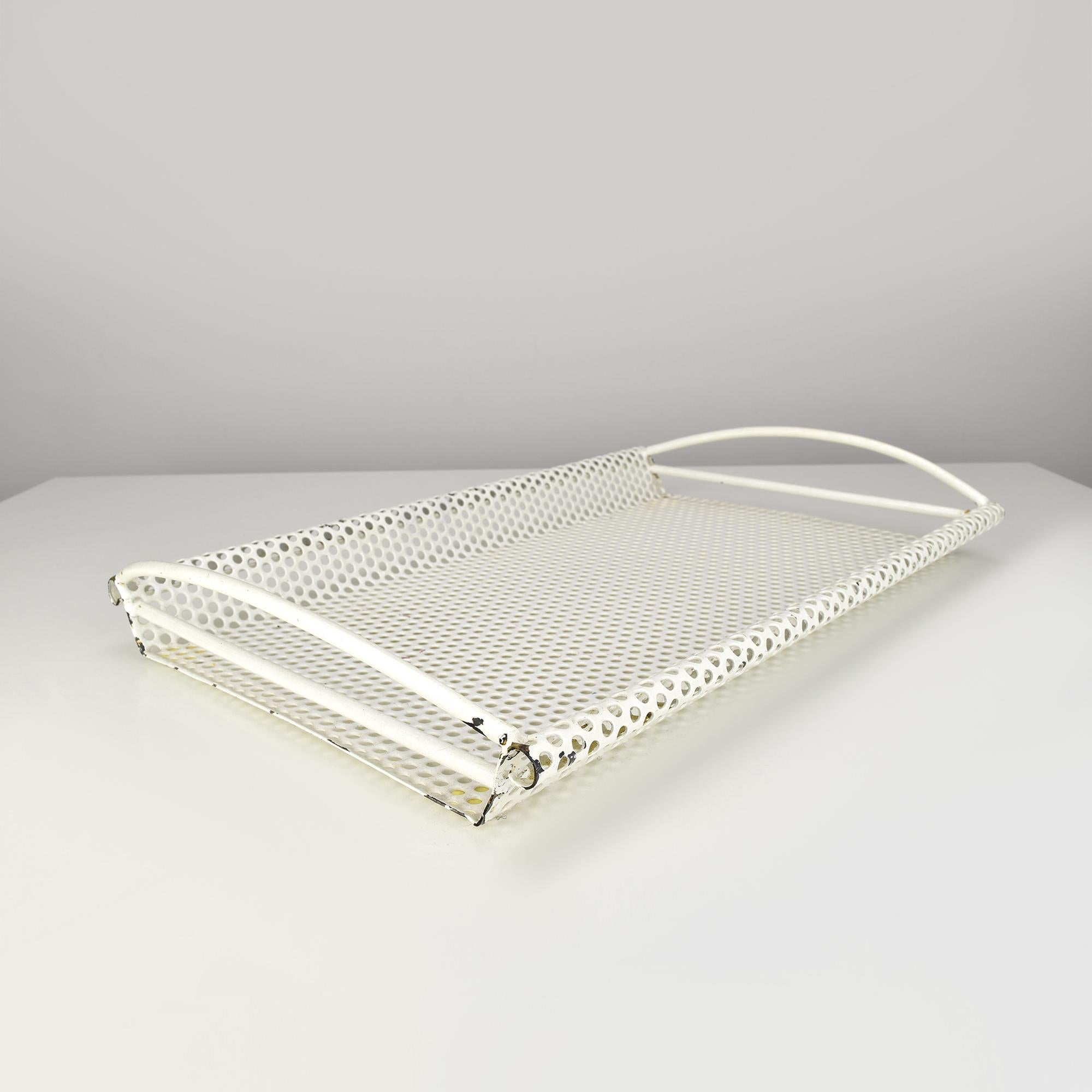 This vintage tray embodies the elegance of Mathieu Mategot's design aesthetic, featuring perforated metal construction and a sleek white finish. The lightweight yet durable design includes gracefully curved handles, combining functionality with
