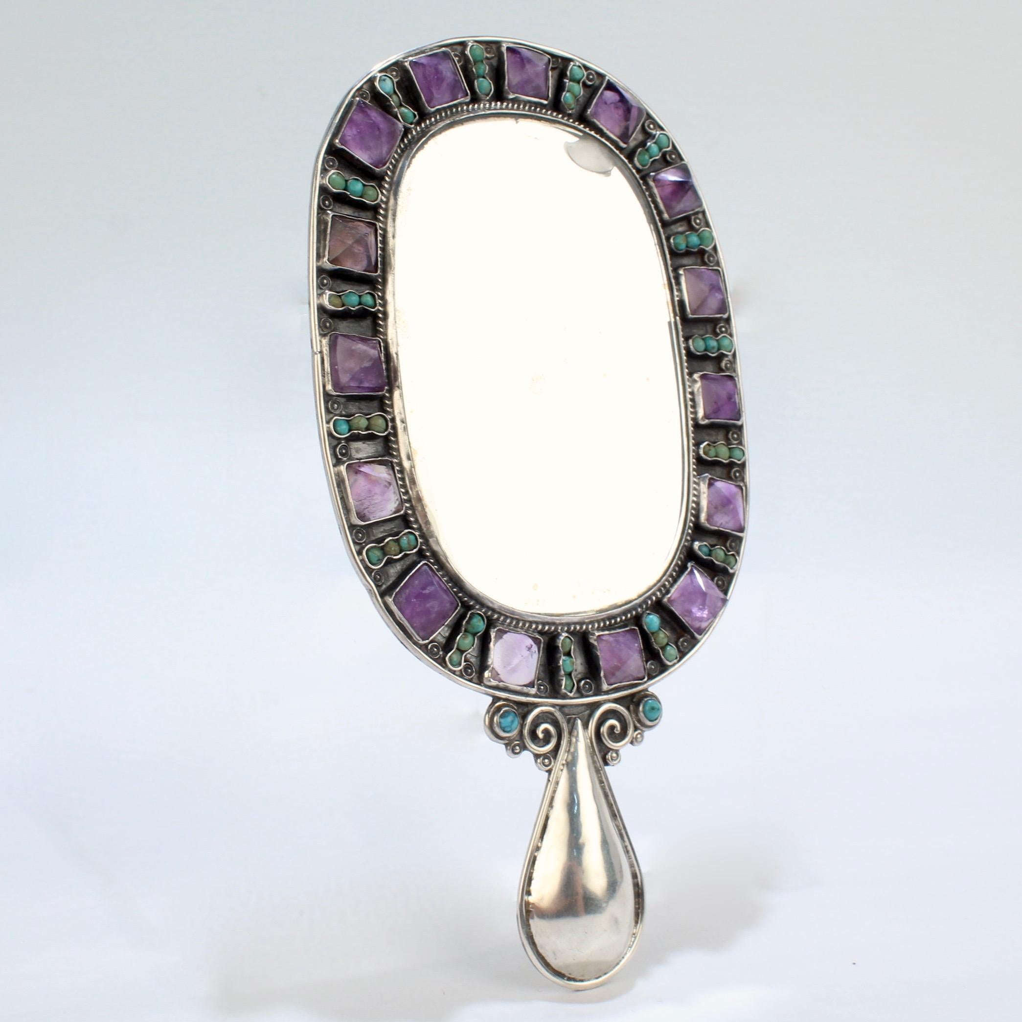 A rare small-scale hand mirror by Matilde Poulat.

The mirror is set in sterling silver and surrounded by pyramid shaped amethyst and round turquoise gemstones. 

Matilde Poulat's work is amongst the most desirable of the Mid-Century Mexican