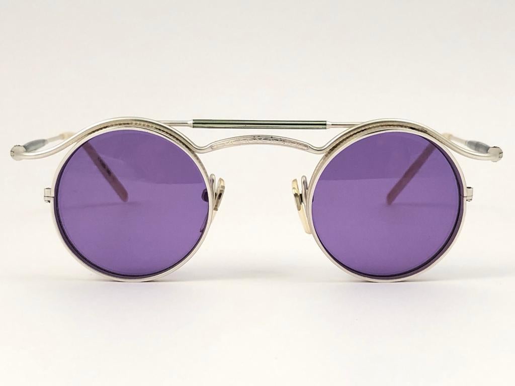 Cult brand Matsuda signed this ultra chic pair of silver matte frame with a beautiful pair of medium purple lenses.


Superior quality and design. 

This item show minor sign of wear due to storage.

MEASUREMENTS 

FRONT : 13 CMS 
LENS HEIGHT : 41