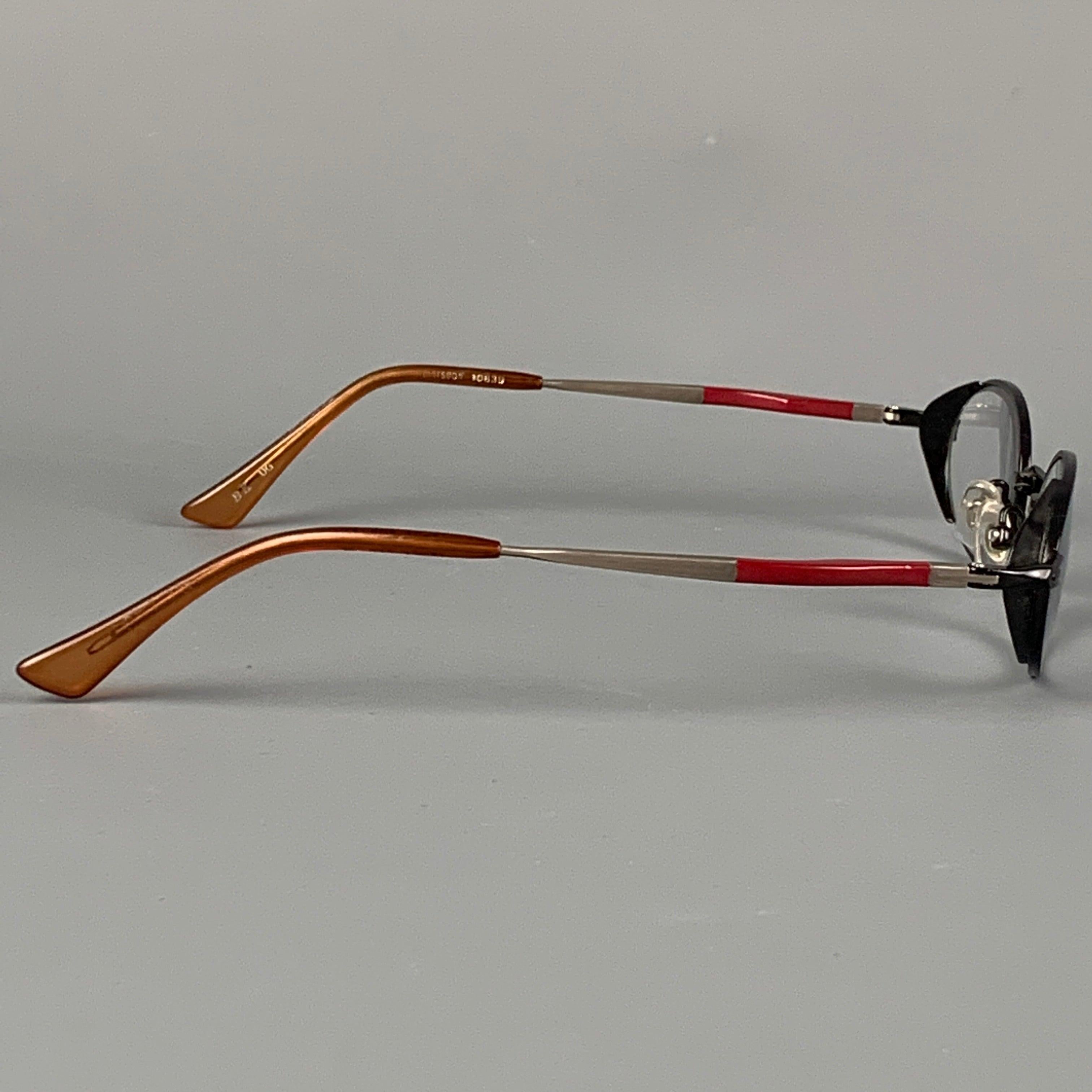 Vintage MATSUDA eyewear comes in a black & red metal featuring silver tone hardware and tinted lenses. Made in Japan.
 Good
 Pre-Owned Condition. 
 

 Marked:  BK UG  
 

 Measurements: 
  Length: 13.5 cm. Height: 1.5 cm.
  
  
  
 Sui Generis
