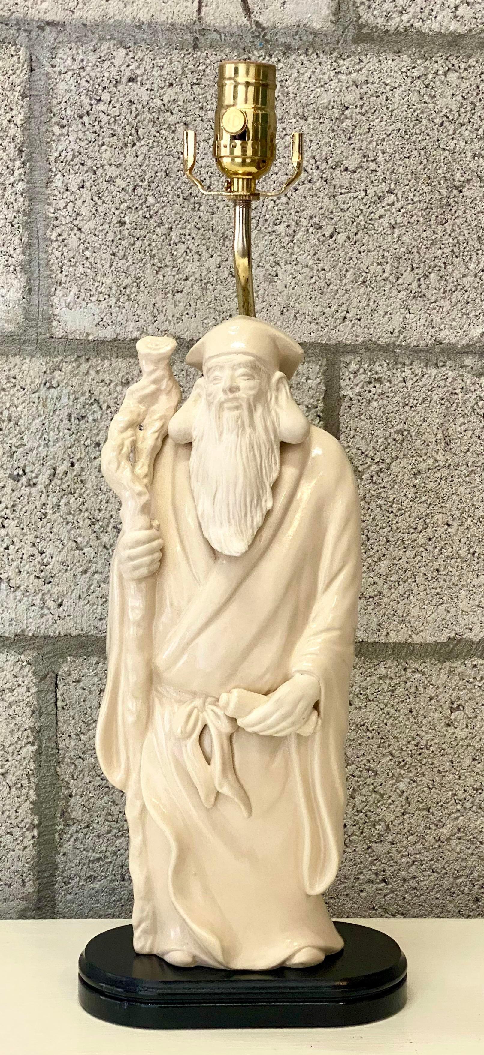 Outstanding vintage matte ceramic table lamp. One of the Asian Immortals. A wise looking elder with a long flowing beard. Rests on a black wooden plinth. Completely restored by Heath of Palm Beach. All new hardware and wiring. Acquired from a Palm