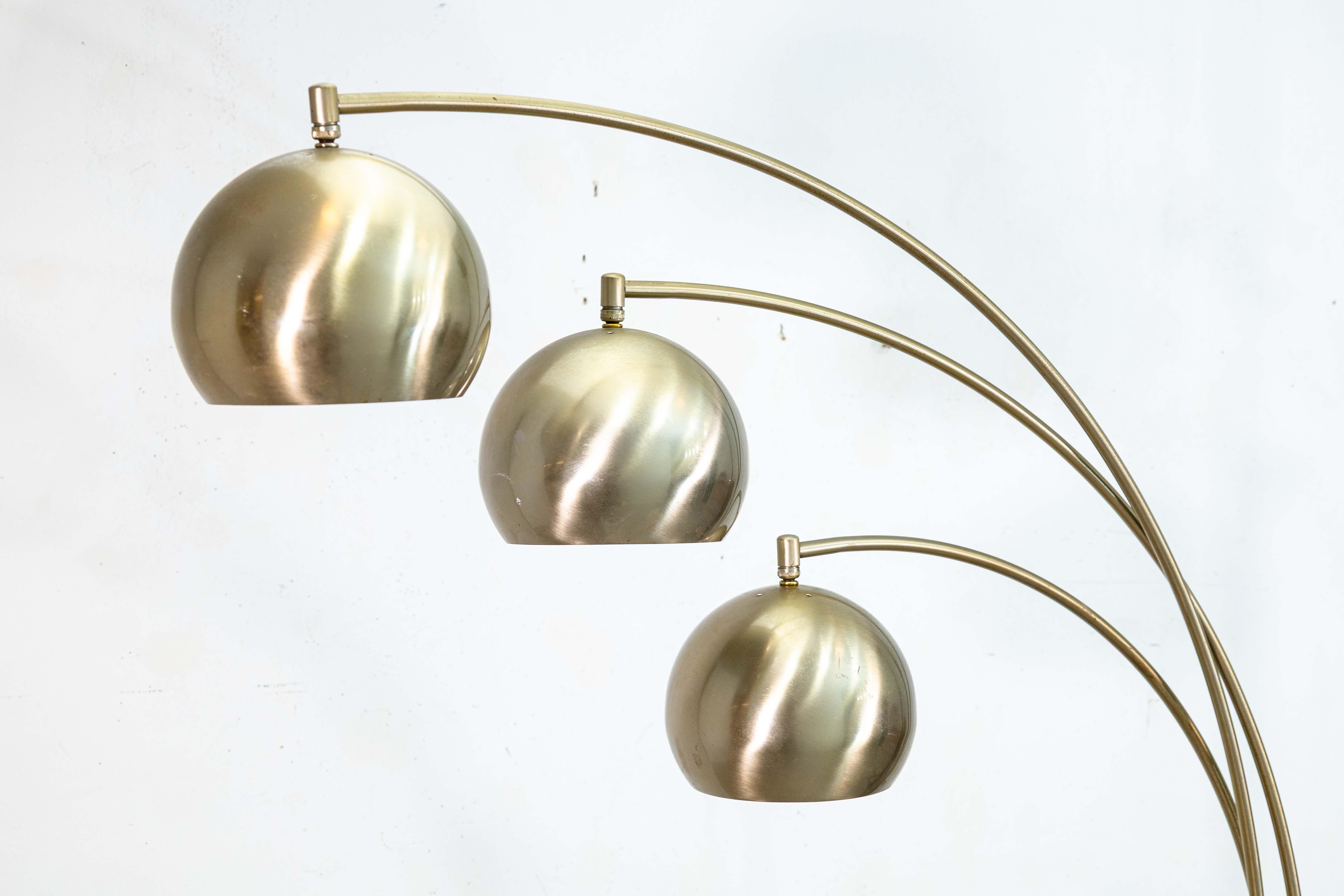 Una lampada ad arco a 3 bracci vintage. Questa graziosa lampada da terra vintage ha un classico design moderno di metà secolo, caratterizzato da 3 bracci con teste di lampada a forma di cupola. Ognuno dei 3 bracci è completamente regolabile a 360