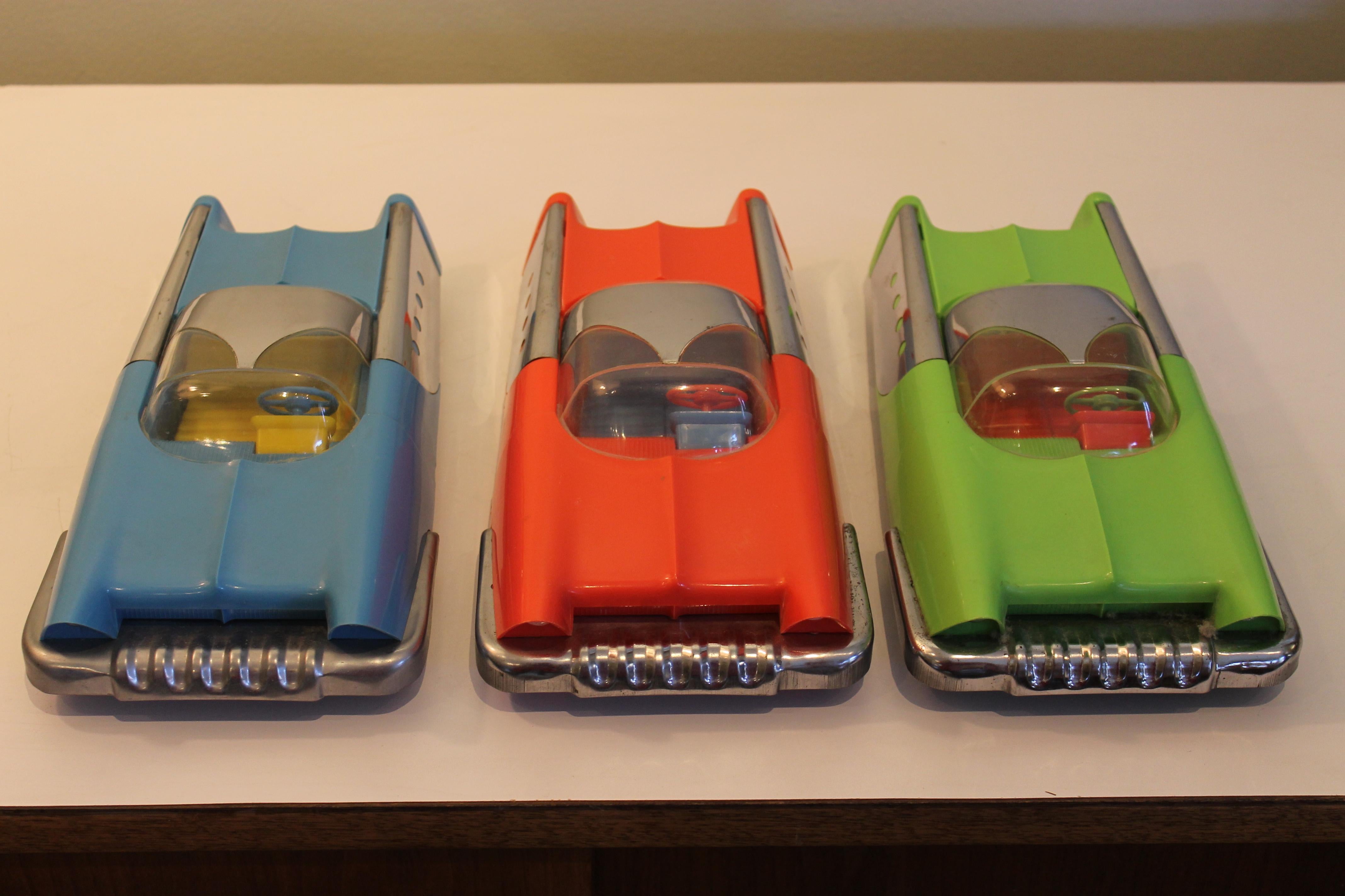 A set of three plastic and steel futuristic toy cars made by Mattel in 1953. Friction powered front axles. Metal accents are chrome-plated steel. These are all complete with steering wheels and removable bubble tops. Measurements (for each car) are