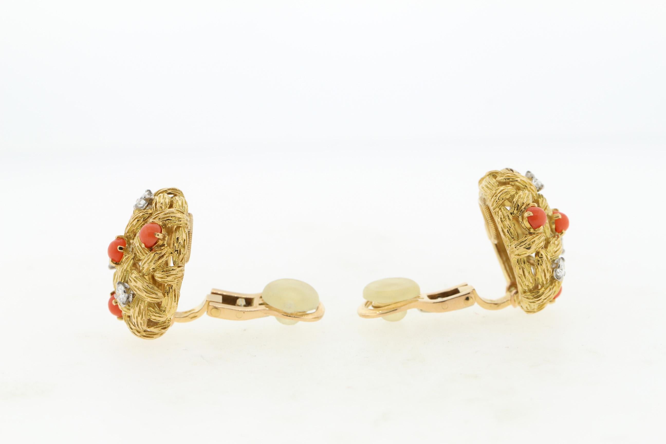 Vintage round textured 18k yellow gold ear clips set with coral and diamonds by Mauboussin, circa 1960. These fun button earrings have a basketweave design with braided gold. They are set with round coral and 6 diamonds weighing approximately 0.24