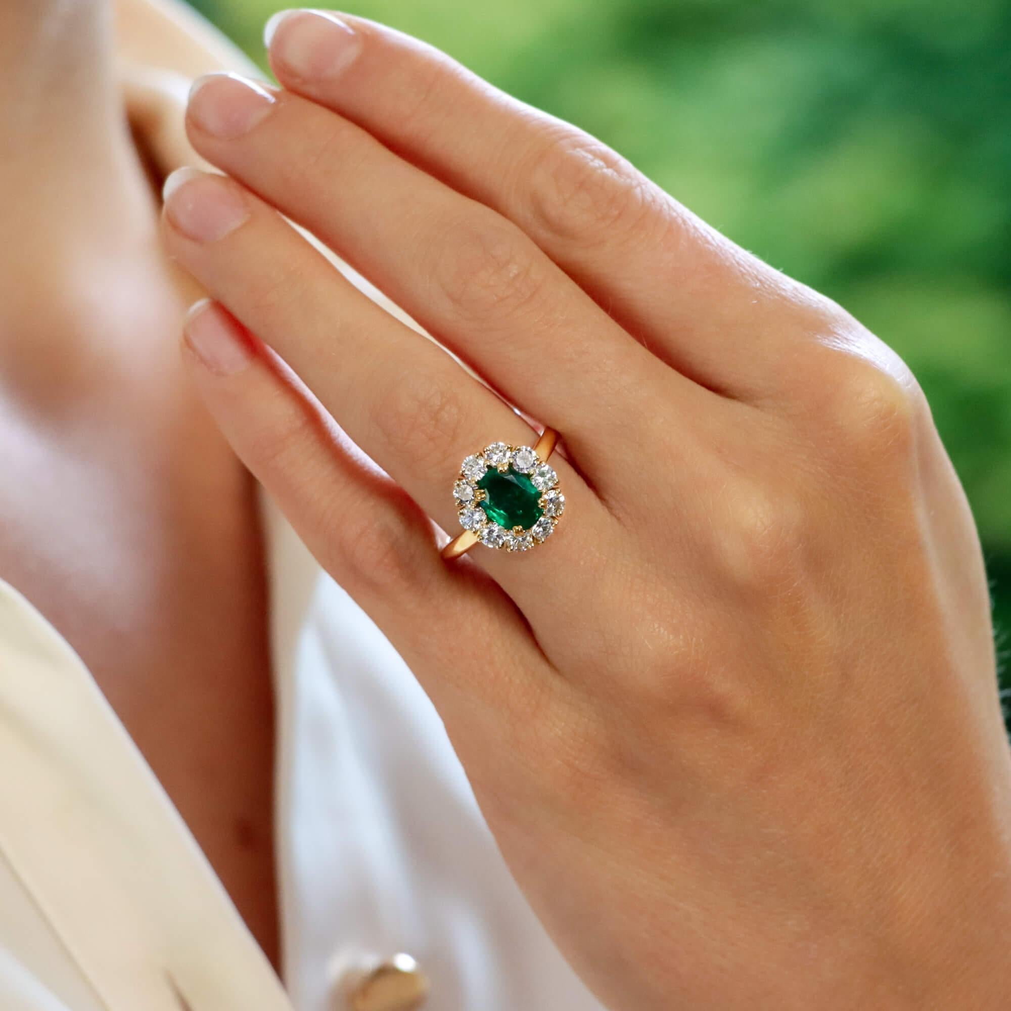 A beautiful vintage Mauboussin emerald and diamond cluster ring set in 18k yellow gold.

The piece is centrally set with a vibrant oval cut emerald which is claw set in yellow gold. The emerald has a fantastic vibrant green colour to it and is