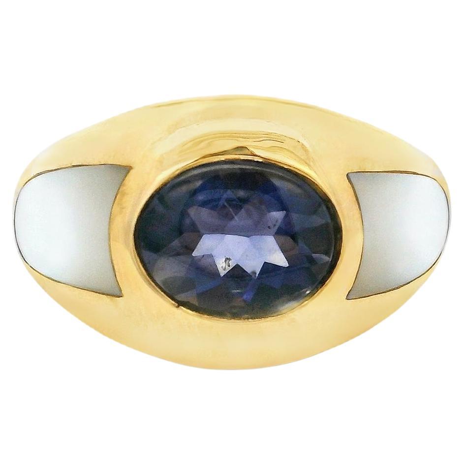 Découvrez l'élégance française intemporelle avec cette bague dôme vintage de Mauboussin, réalisée en or jaune 18 carats et sertie en son centre d'une iolite bleue de 1,5 carat de taille ovale. La forme sculpturale audacieuse est rehaussée par des