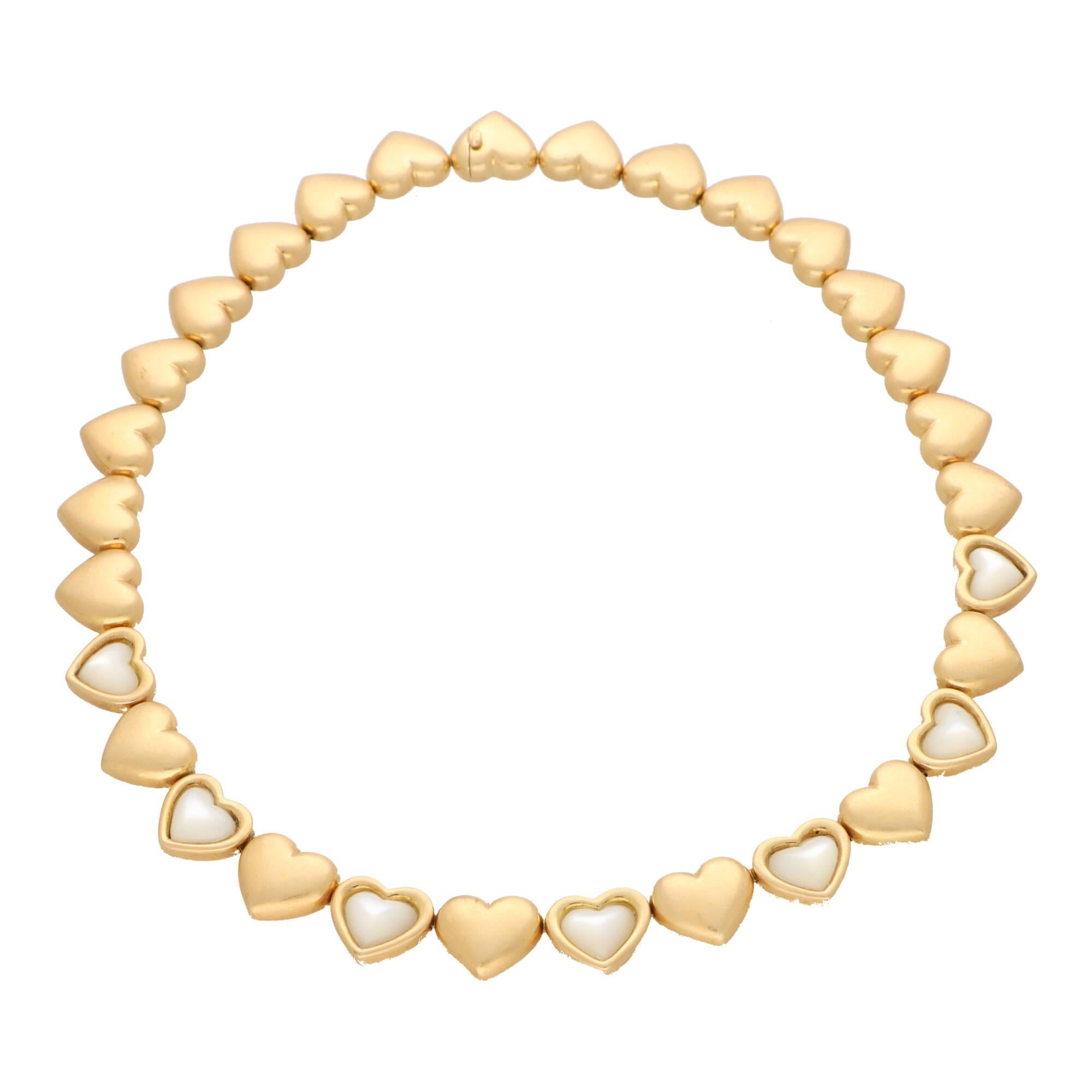 A beautiful vintage Mauboussin mother of pearl heart necklace set in 18k yellow gold.

The necklace is composed of 30 individual brushed yellow gold heart motif links, connected together via an articulated fastening. Towards the centre aspect of the