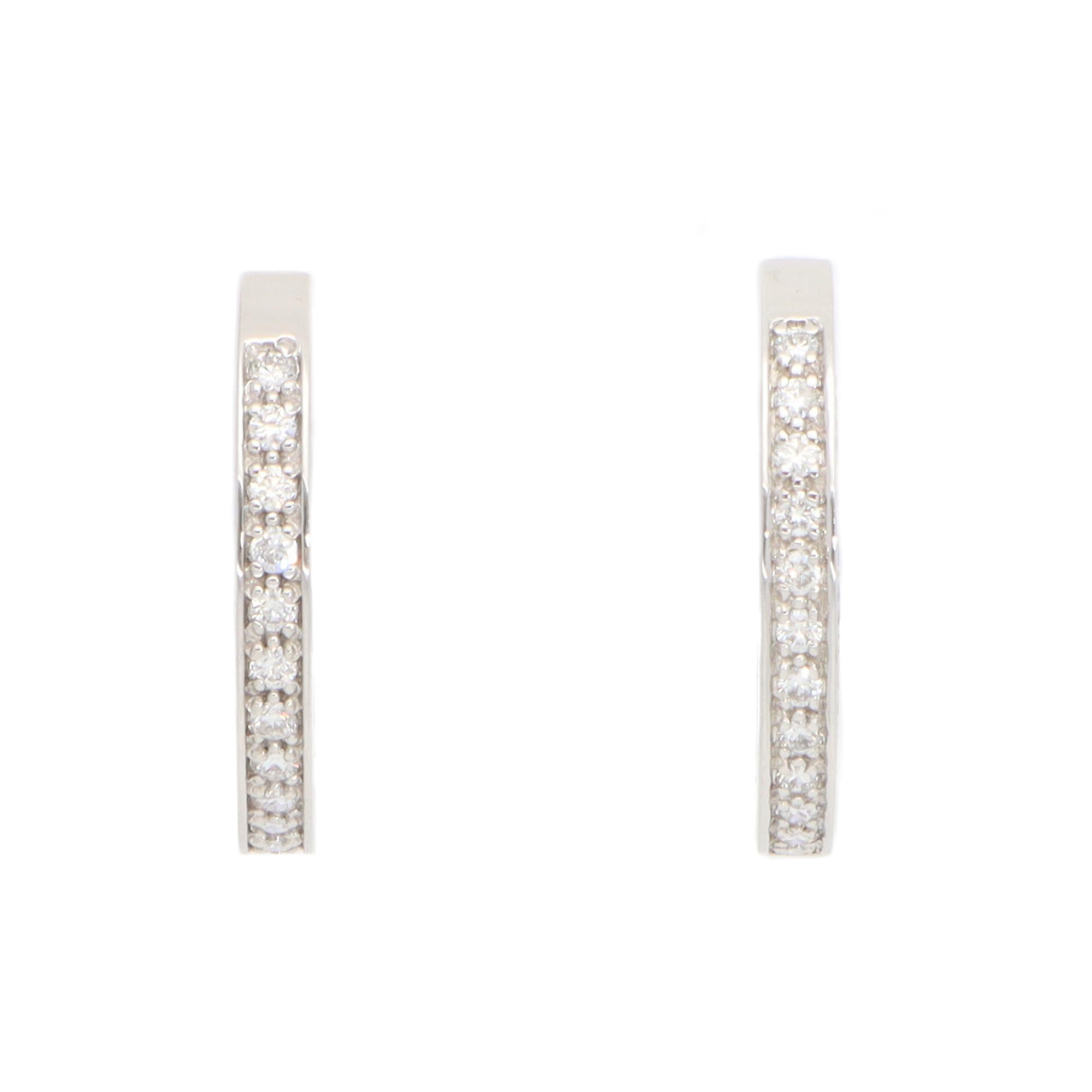 A classic pair of vintage Mauboussin Paris diamond hoop earrings set in 18k white gold.

Each earring depicts a polished white gold hoop, which is set with a fine line of 12 round brilliant-cut diamonds. These diamonds are securely set by pavé bead