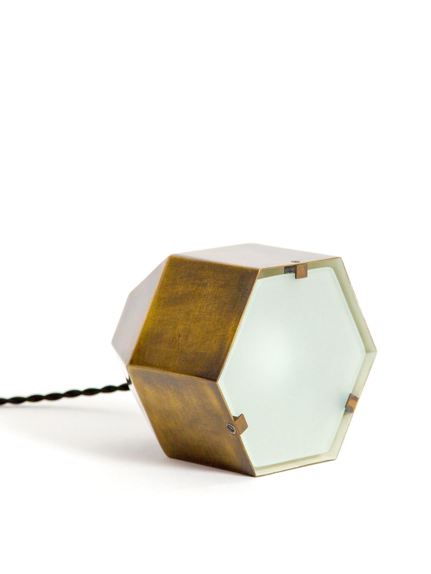 Very rare and highly collectible, model #2202, table lamp designed by Max Ingrand for Fontana Arte. The playful hexagon shape allows the lamp to sit in multiple positions. The beautifully crafted body, made from oxidized brass, holds the etched