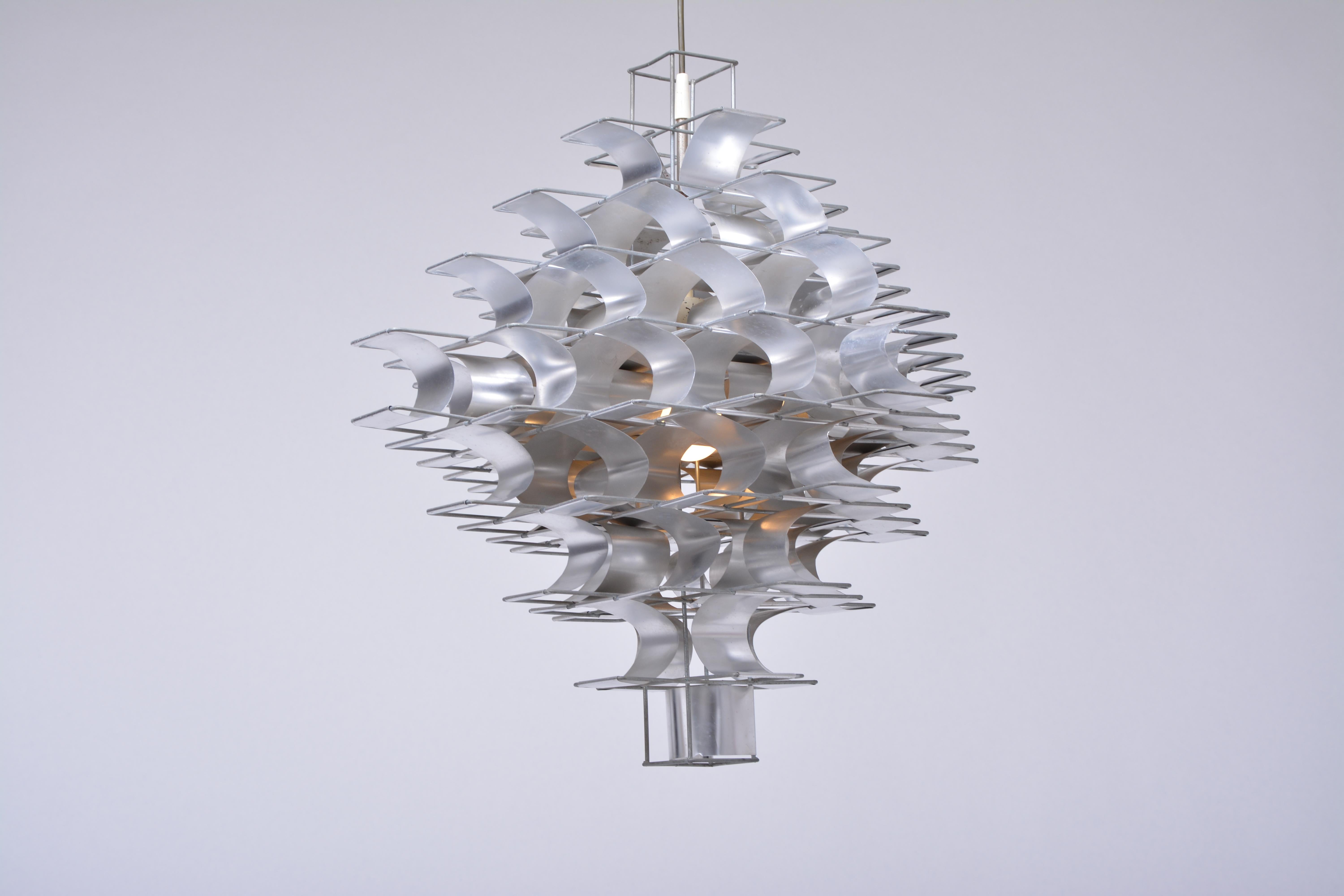 An aluminium and steel chandelier “Cassiopé”, designed in 1969 by Max Sauze and produced by Atelier Sauze in the 1970s.
Metal wire and aluminum strip construction, fitted with an E 27 lamp holder.
Originally this chandelier was designed for the