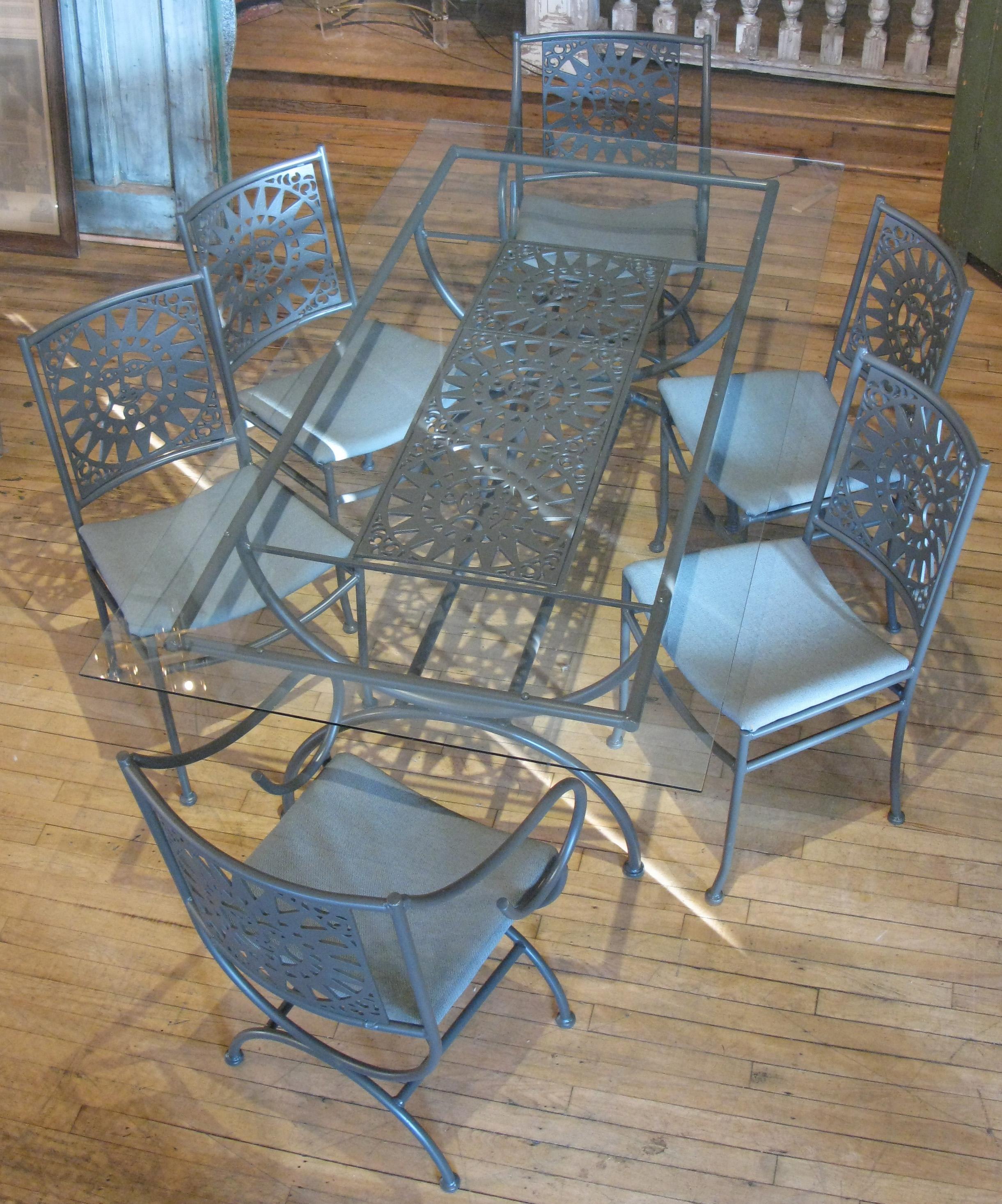 A vintage 1960s dining set designed by Arthur Umanoff, with frames in aluminum and seat backs and the table base with wrought iron panels depicting the Mayan Sun. Beautiful set just refinished in greige, with seats recovered in slate gray. The table