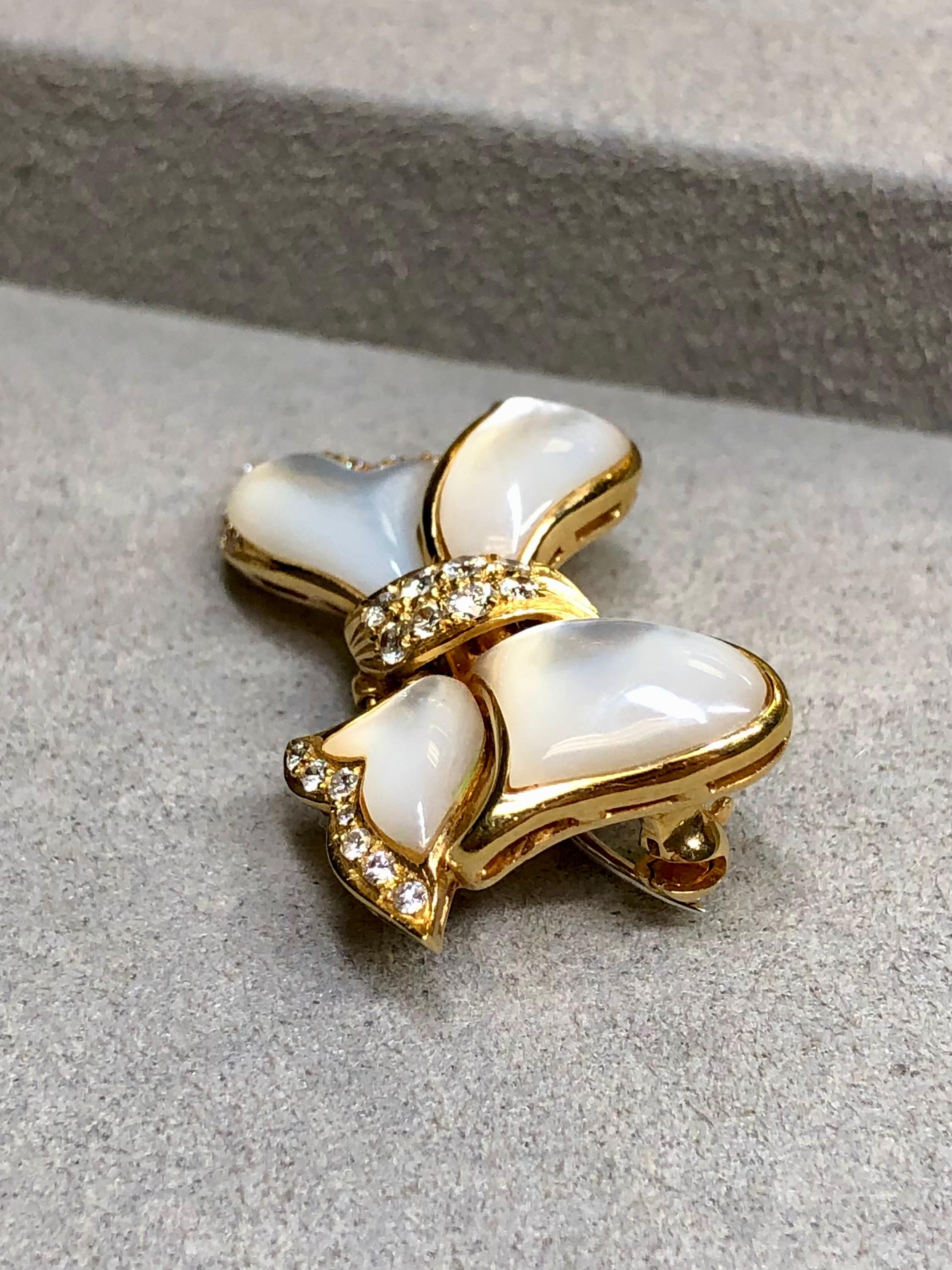 An elegant little pin by well known retail jeweler, Mayor’s. It is crafted in 18K yellow, gold and inlaid with beautiful white mother of pearl as well as bead set with approximately .50ctw in F-G color Vs-2 clarity round diamonds. The pin portion on