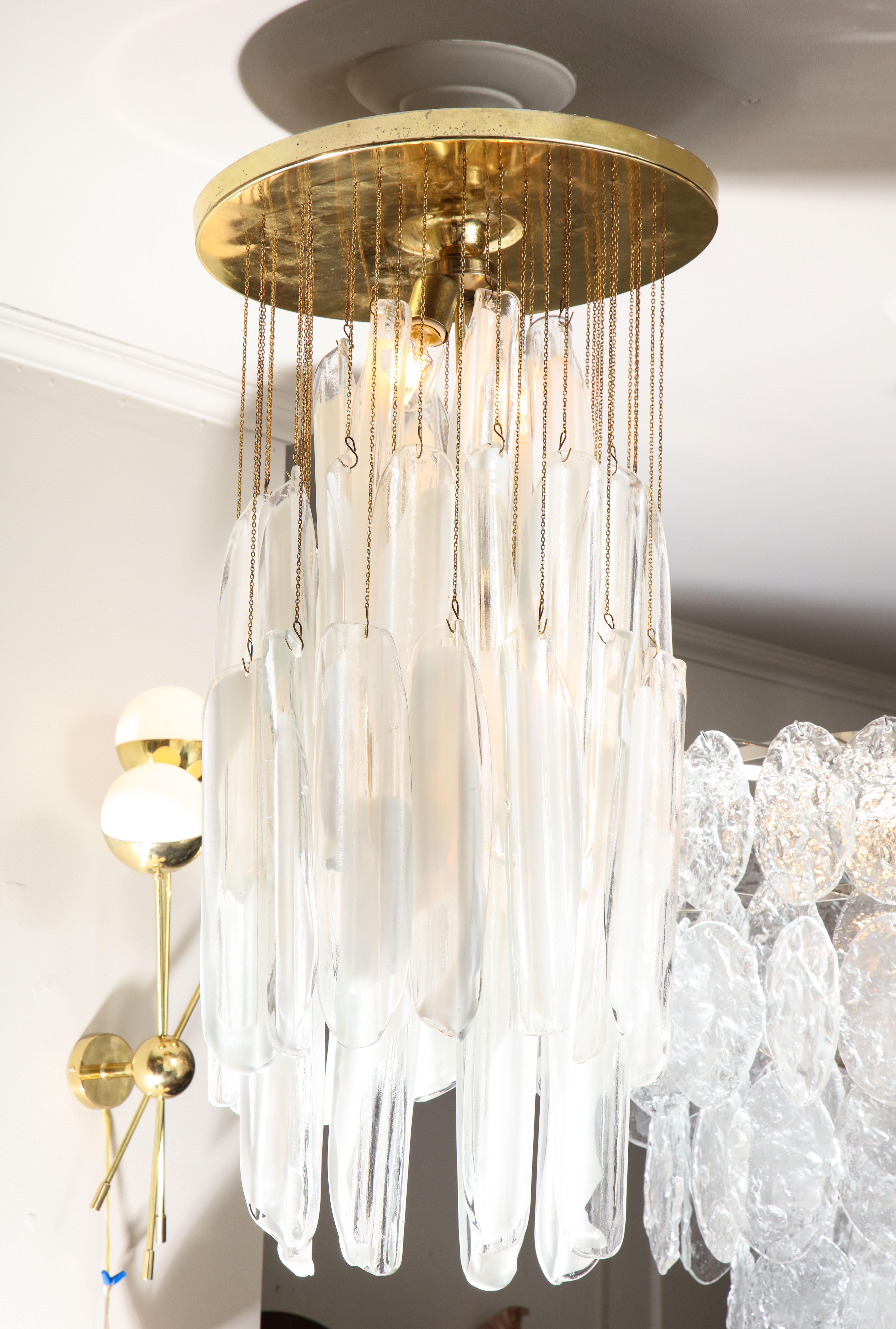 Elegant Mazzega glass chandelier with clear and white oblong leaf glass, designed by Mazzega in 1960's. Each piece has a unique stream of white stripe on clear glass that was created with exceptional technique used by a glass artisans in Murano,
