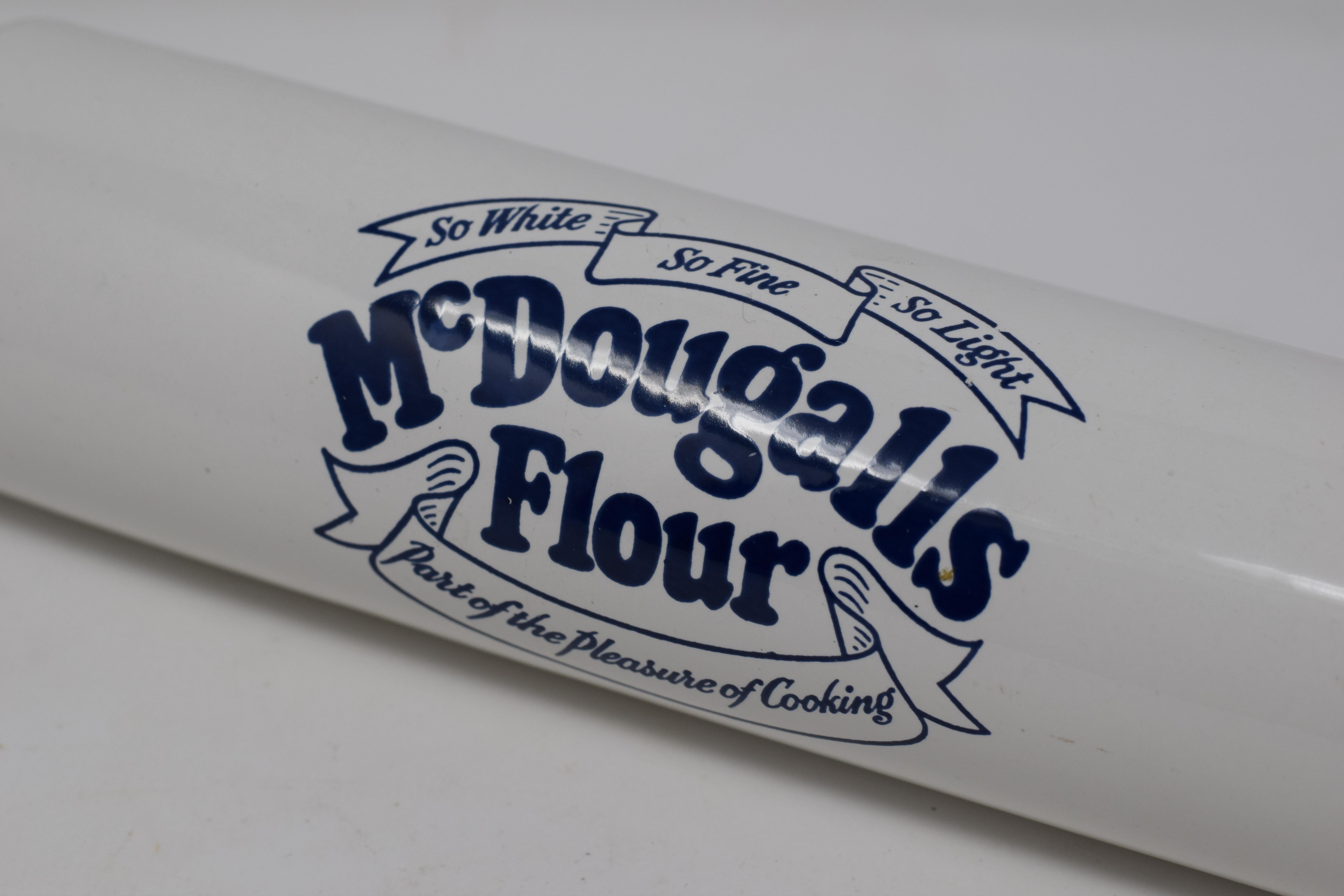 This is a vintage McDougalls advertising rolling pin with blue transfer print. The rolling pin features a central pin with wood handles at each end. McDougalls has been providing consumers with high quality flours for baking since the English