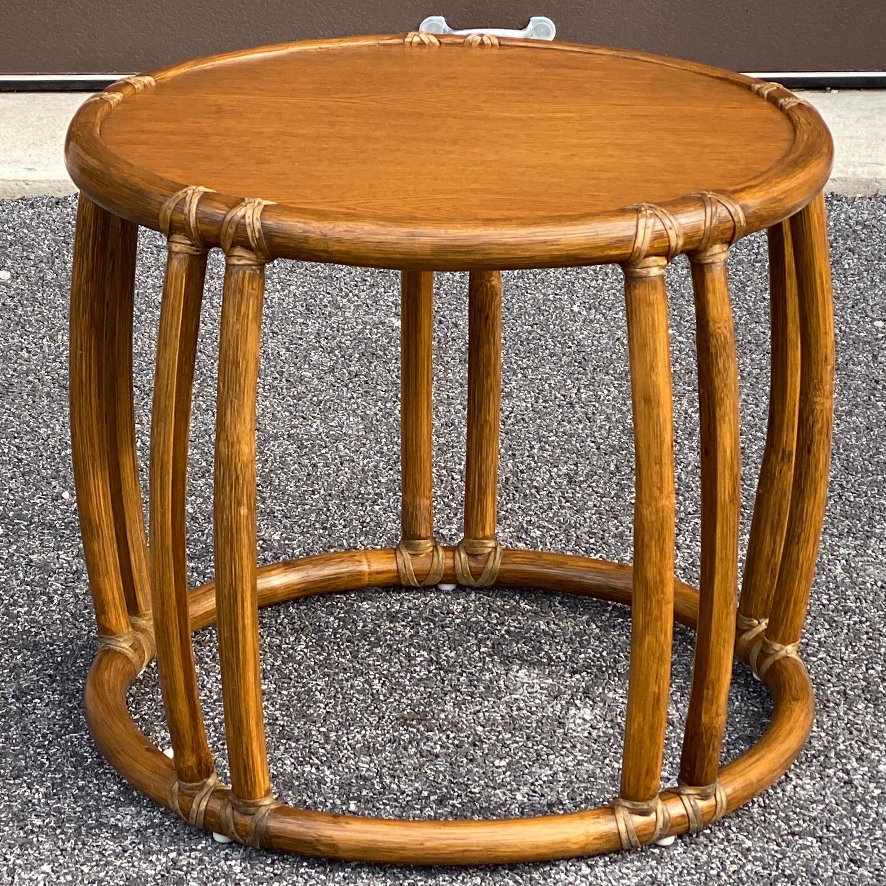 A genuine McGuire taboret table with the signature leather wrapped joints and original metal tag underneath. Interior table surface 21.5” diameter. On page 34 of the McGuire Furniture Portfolio this piece is identified as Model 95X Lamp Table. The