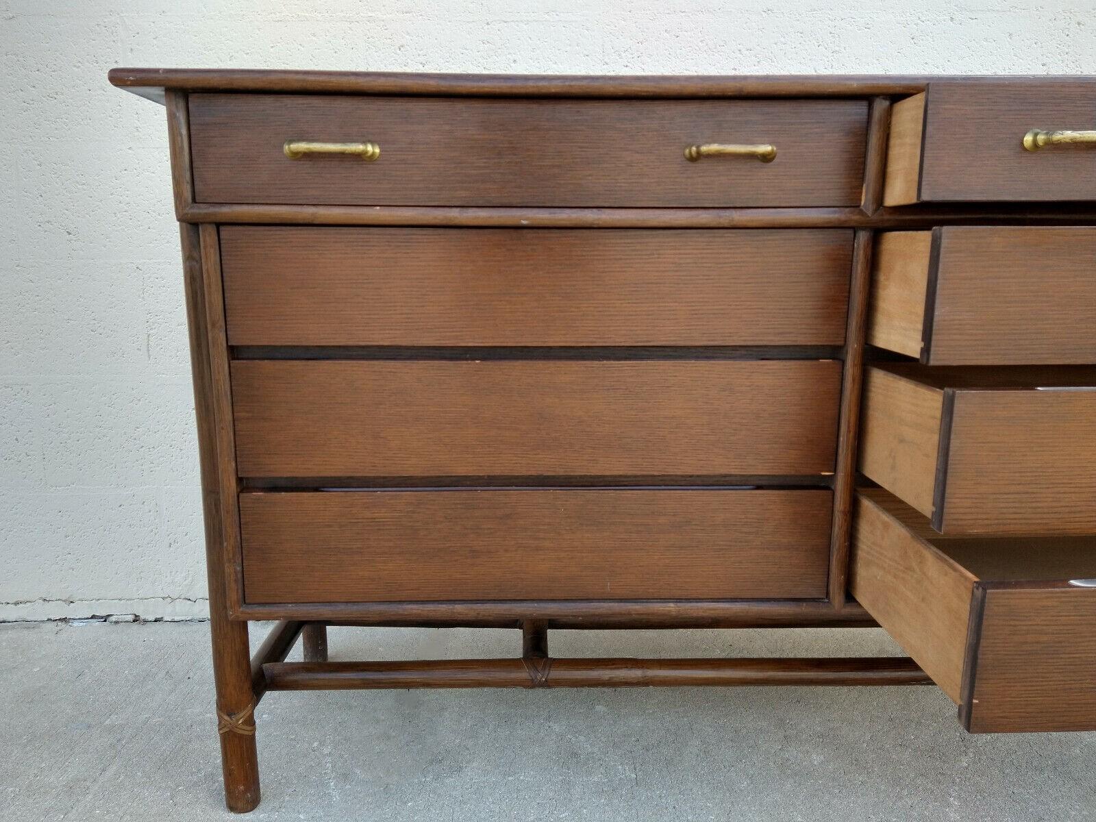 Hard to find Mid-Century Modern oak and rattan double chest by McGuire. The expertly crafted oak case has side mounted rattan legs reinforced with stretchers underneath. Rattan is detailed with McGuire's signature laced rawhide. This vintage chest