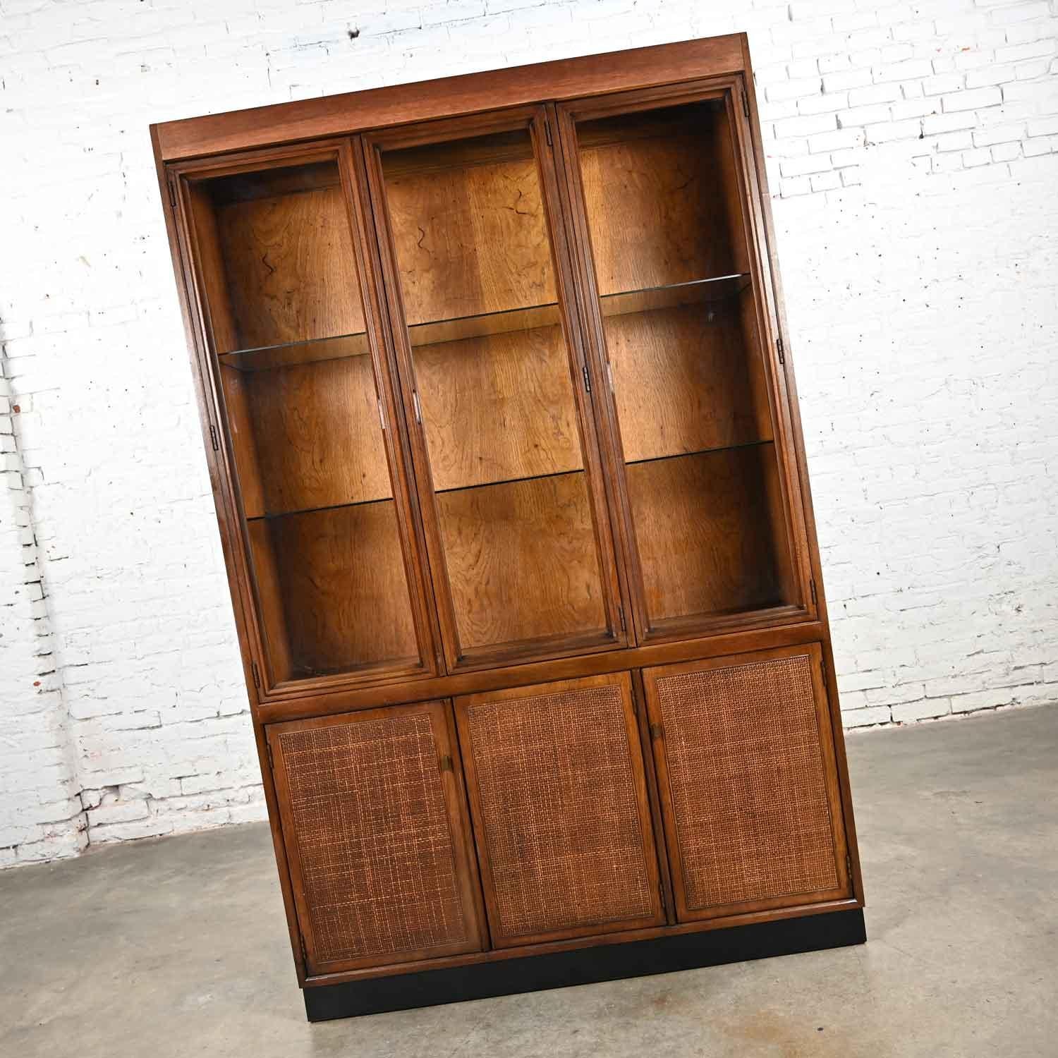 Fabulous vintage Mid-Century Modern 1 piece walnut & radio weave cane front lighted China cabinet, hutch, or display cabinet with glass shelves and brass knobs. Beautiful condition, keeping in mind that this is vintage and not new so will have signs