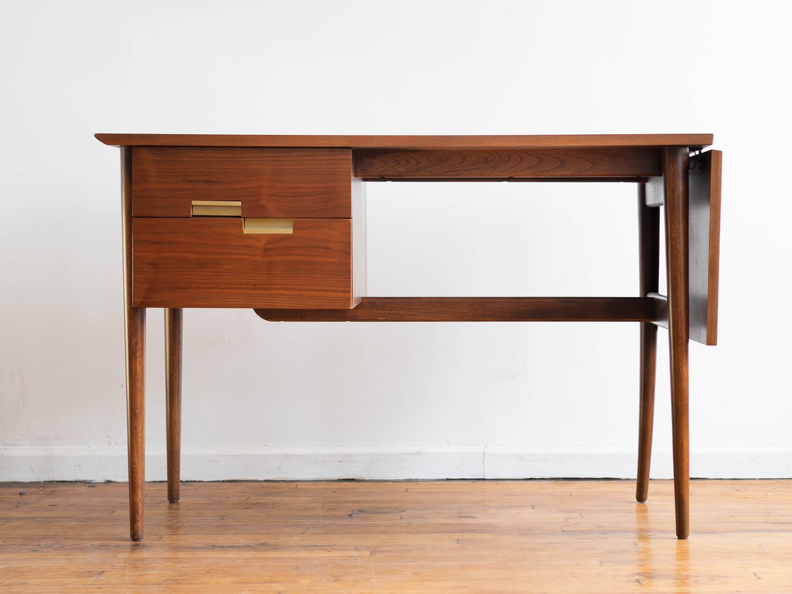 44” x 23” x 29.5”H; leaf adds 14”; knee hole is approx. 22.5” x 28.5”H

Vintage Mid-Century Modern American of Martinsville Accord petite drop leaf writing desk in walnut. Warm walnut woodgrain with two spacious drawers a contrasting-grain drop