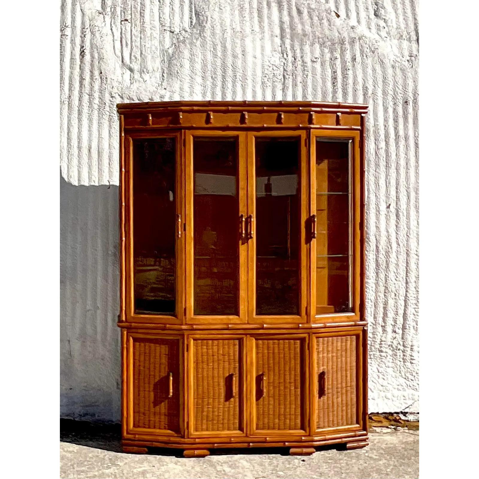A fabulous vintage Coastal MCM china cabinet. Made by the iconic American Of Martinsville. Beautiful faux carved bamboo with a chic angled design. Lots of great storage below. Acquired from a Palm Beach estate.