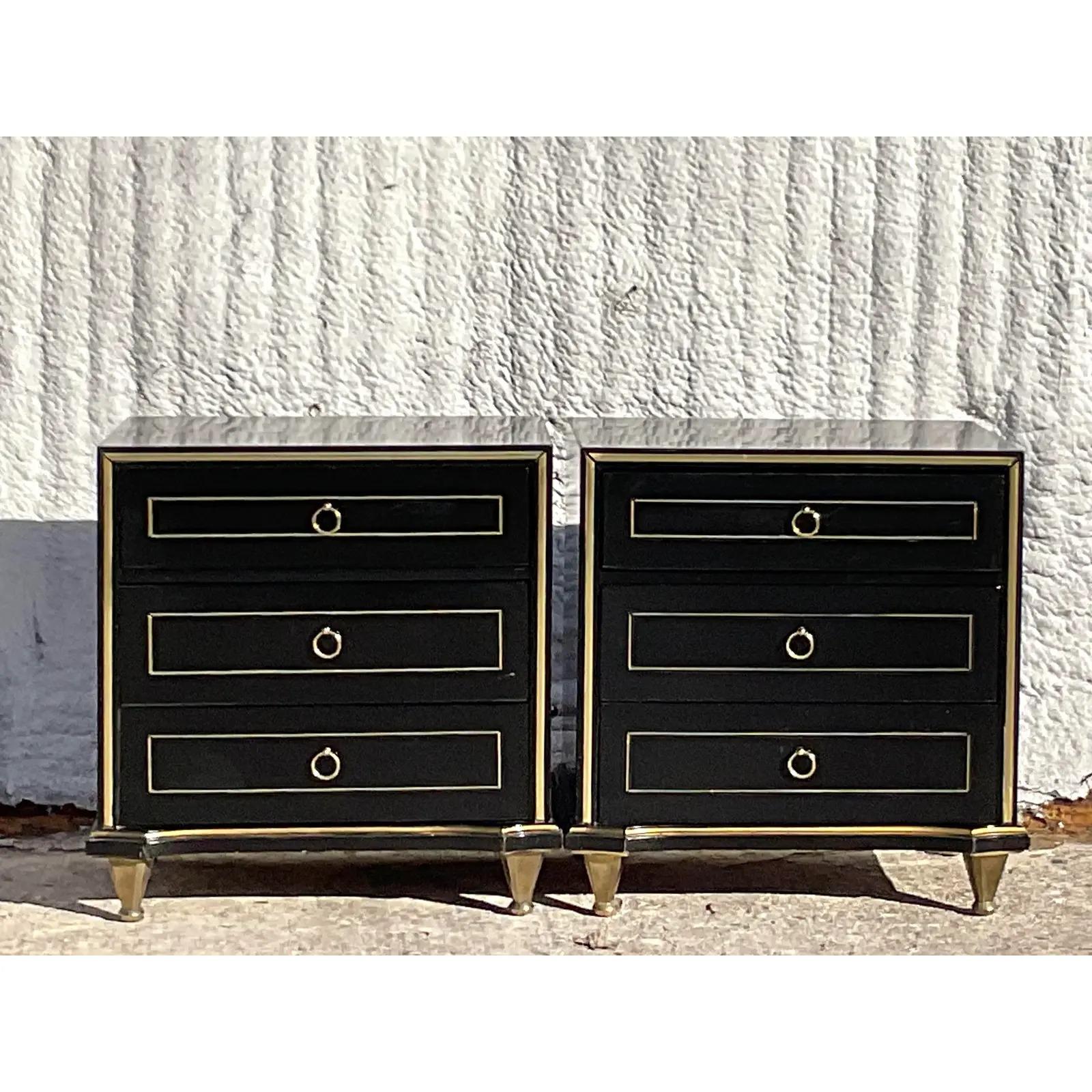 A fantastic pair of vintage MCM nightstands. A beautiful custom black lacquer fining with gilt tipping and brass hardware. Done in the manner of American of Martinsville. Acquired from a Palm Beach estate.