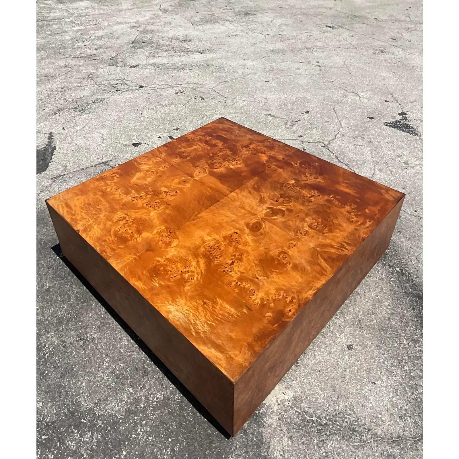 Fantastic vintage MCM Burl wood coffee table. Beautiful book matched Burl in a chic floating design. Rests on a wooden plinth. Done in the manner of Milo Baughman. Acquired from a Palm a each estate.