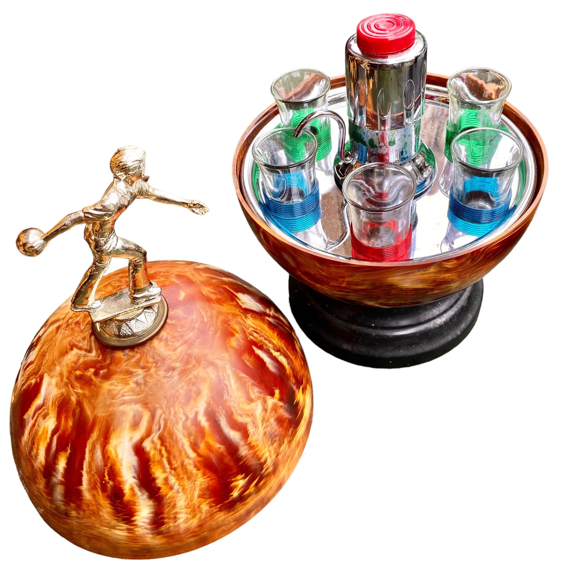 A truly unique Mid-Century Modern bowling ball/liquor dispensing bowling trophy. A very rare find!
The top half of the ball lifts off to reveal a Merry-Go-Round style liquor dispensing pump and 6 colorfully accented art glass shot